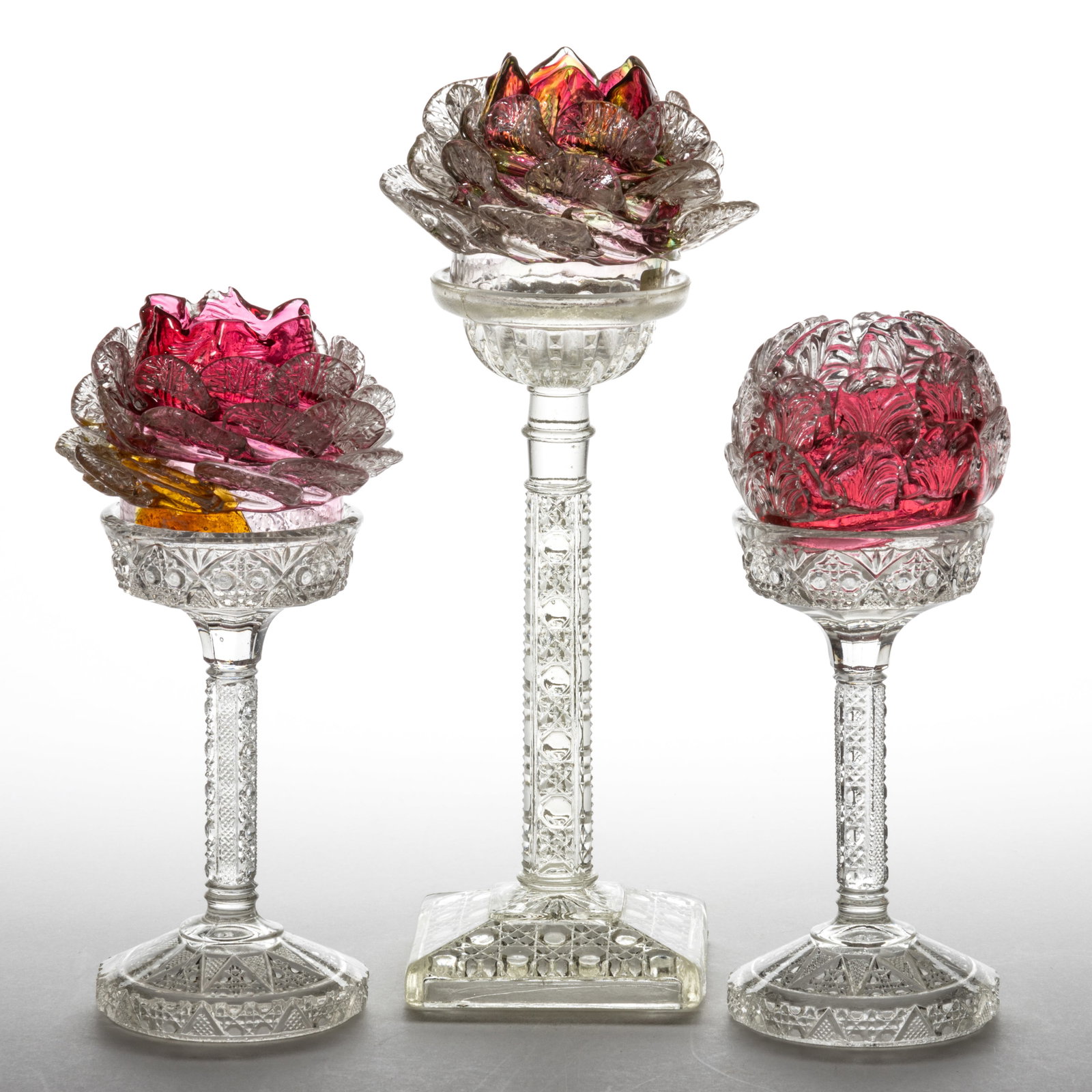 FLORAL PETAL ART GLASS PEDESTAL FAIRY LAMPS, LOT OF THREE: FLORAL PETAL ART GLASS PEDESTAL FAIRY LAMPS, LOT OF THREE, cranberry, rubina and remaining example having alternating cranberry and yellow-green diagonal panels, two examples with 