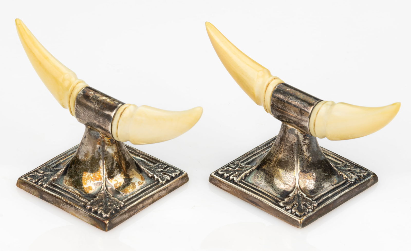 ENGLISH EDWARDIAN STERLING SILVER KNIFE RESTS, PAIR: ENGLISH EDWARDIAN STERLING SILVER KNIFE RESTS, PAIR, each having a weighted square base with bas-relief leaves to corners, top set with horn-shaped carved bone rests, presented in original retailer