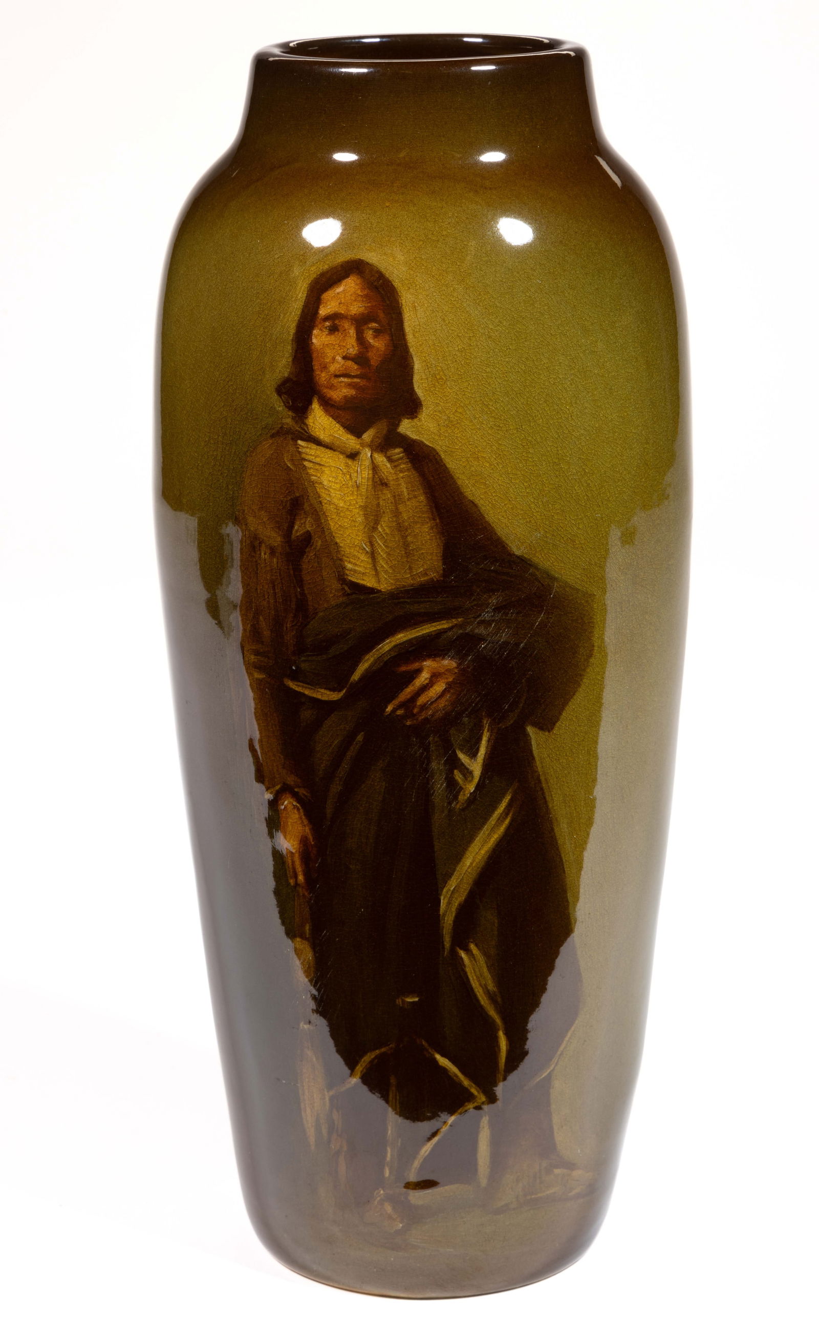 ROOKWOOD POTTERY SIGNED GRACE YOUNG (AMERICAN, 1869-1947) NATIVE AMERICAN VASE: ROOKWOOD POTTERY SIGNED GRACE YOUNG (AMERICAN, 1869-1947) NATIVE AMERICAN VASE, featuring a polychrome hand-painted standing indigenous man wearing a bone breastplate and holding a blanket,&