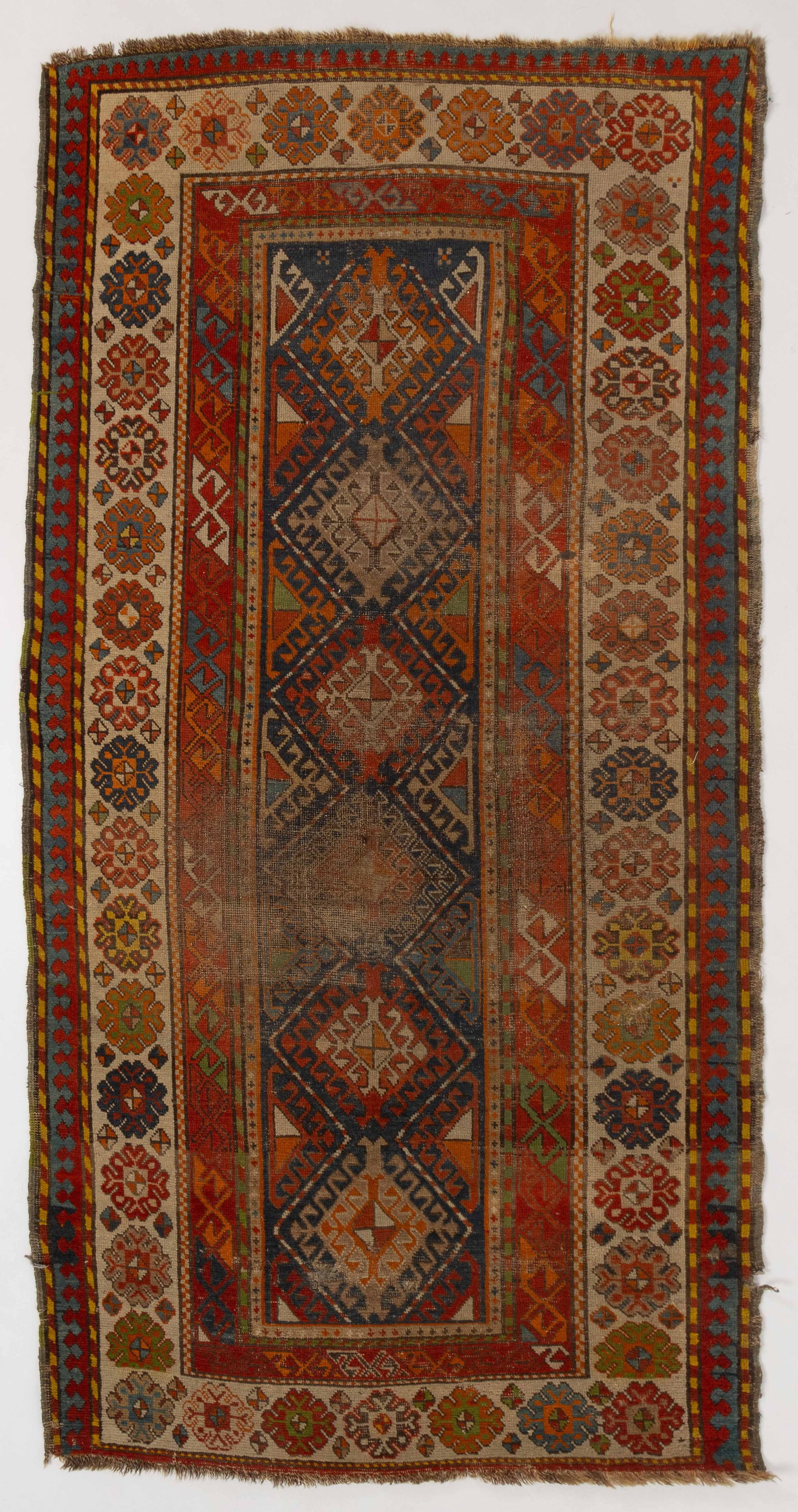 ANTIQUE CAUCASIAN ORIENTAL SCATTER RUG: ANTIQUE CAUCASIAN ORIENTAL SCATTER RUG, the central field with a row of six conjoined blue diamond medallions with a geometric "S" motif band over red ground, and an addi