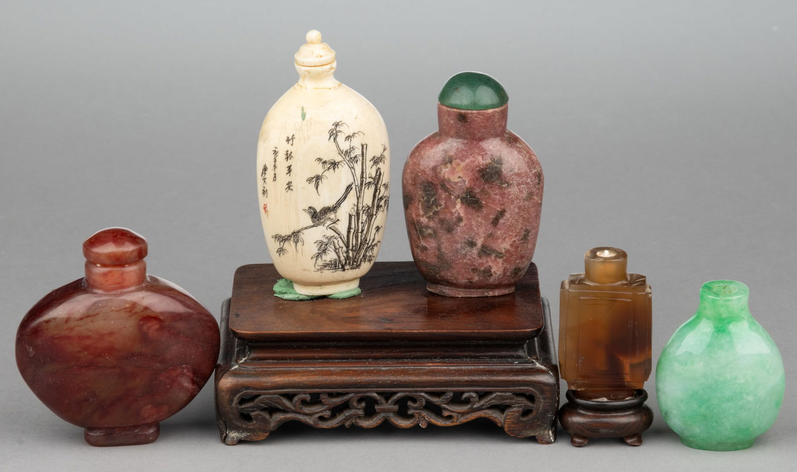 ASSORTED CHINESE / JAPANESE SNUFF BOTTLES, LOT OF FIVE: ASSORTED CHINESE / JAPANESE SNUFF BOTTLES, LOT OF FIVE, comprising five carved stone examples, and one carved bone example with relief-carved figures on one side and bamboo on the other. Together with
