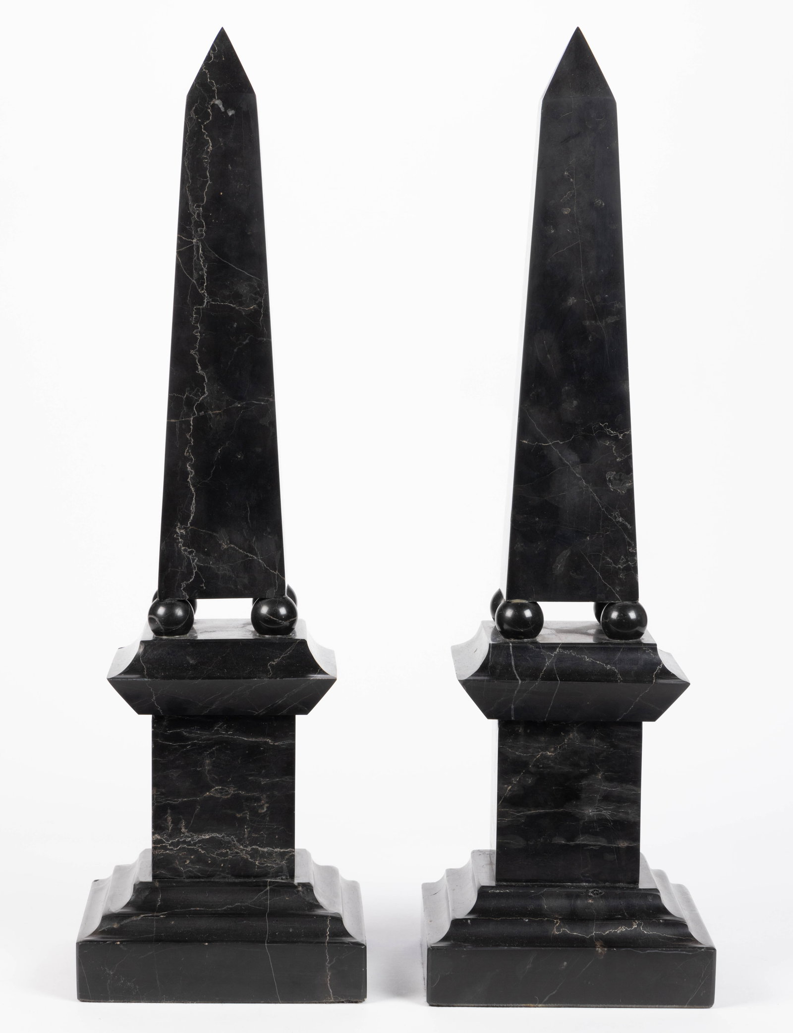 CONTINENTAL BLACK MARBLE OBILISKS, PAIR: CONTINENTAL BLACK MARBLE OBILISKS, PAIR, each featuring four ball-form feet and raised on a square plinth. First half 20th century. 20" H, 5 7/8" SQ base. 