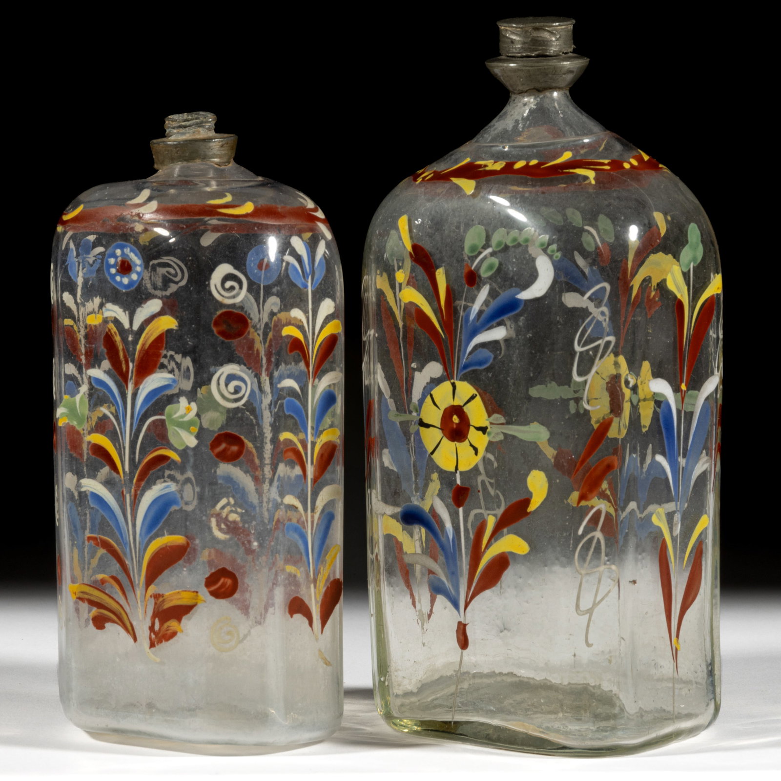 HALF-POST BLOWN AND DECORATED "STIEGEL-TYPE" BOTTLES / FLASKS, LOT OF TWO: HALF-POST BLOWN AND DECORATED "STIEGEL-TYPE" BOTTLES / FLASKS, LOT OF TWO, colorless glass, half-post method, typical flattened octagonal form with beveled corners, hand-painted po