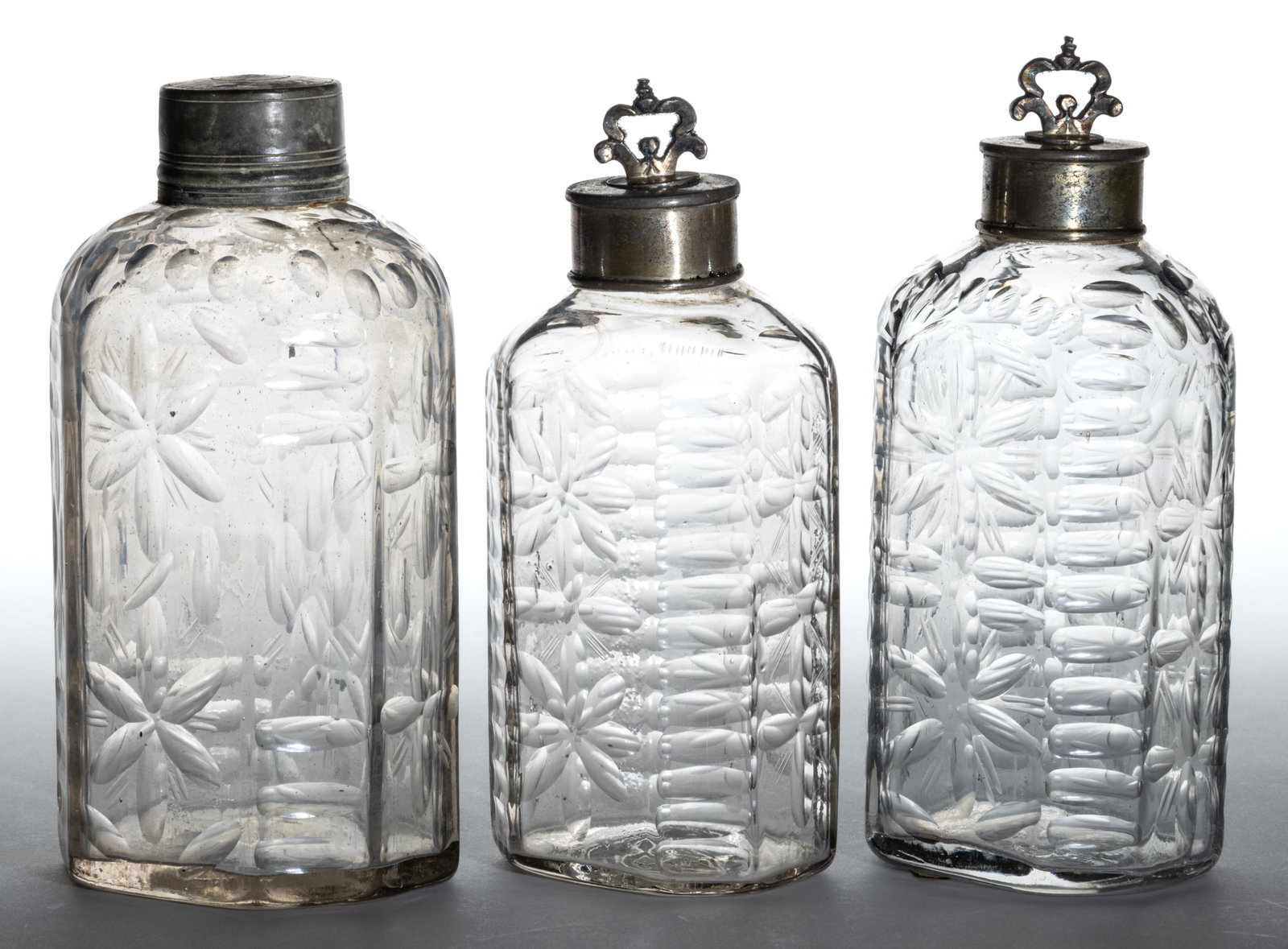HALF-POST BLOWN, CUT, AND ENGRAVED BOTTLES / FLASKS, LOT OF THREE: HALF-POST BLOWN, CUT, AND ENGRAVED BOTTLES / FLASKS, LOT OF THREE, heavy colorless glass, half-post method, typical flattened octagonal form with beveled corners, the surface decorated with exten