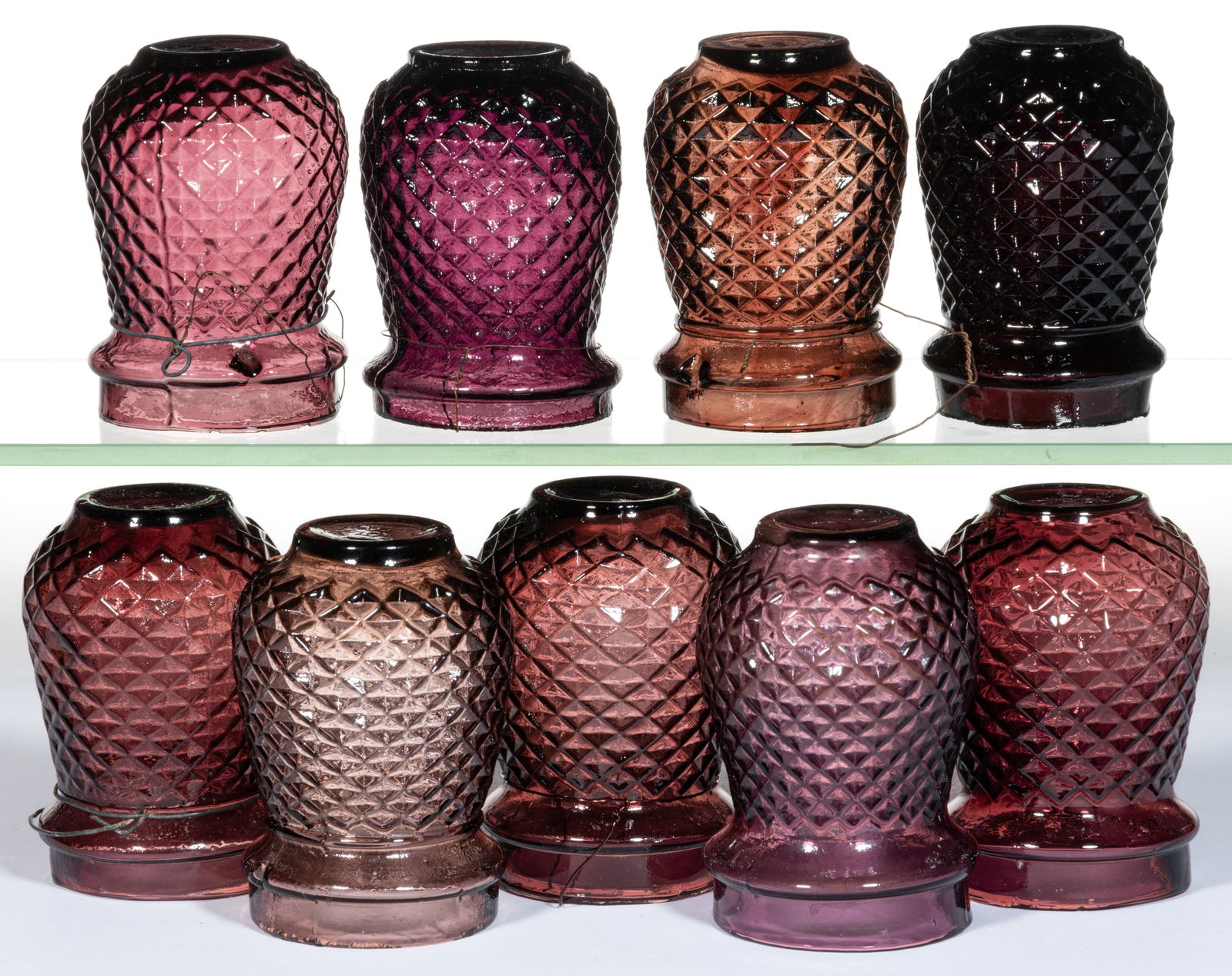 DIAMOND-PATTERN MOLDED GLASS CHRISTMAS LIGHTS, LOT OF NINE: DIAMOND-PATTERN MOLDED GLASS CHRISTMAS LIGHTS, LOT OF NINE, amethyst. Fourth quarter 19th/first quarter 20th century. 3 1/2" to 3 3/4" H. 