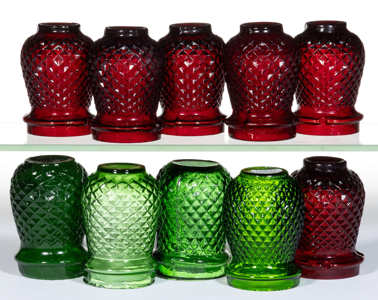 DIAMOND-PATTERN MOLDED GLASS CHRISTMAS LIGHTS, LOT OF TEN: DIAMOND-PATTERN MOLDED GLASS CHRISTMAS LIGHTS, LOT OF TEN, ruby red and green, comprising six ruby and four green examples. Fourth quarter 19th/first quarter 20th century. 3 5/8" to 3 3/4" H