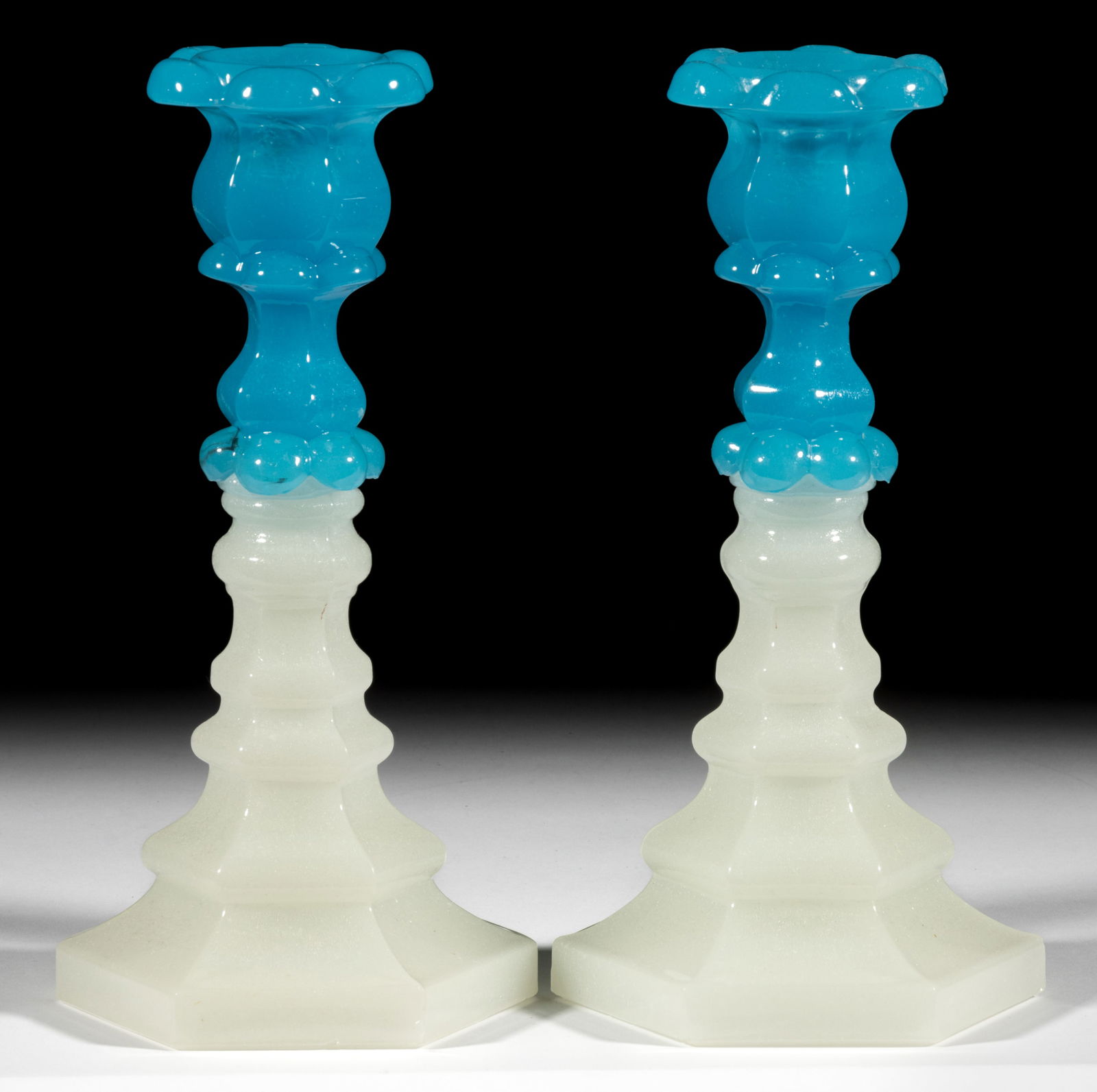 PRESSED PETAL AND HEXAGONAL PAIR OF CANDLESTICKS: PRESSED PETAL AND HEXAGONAL PAIR OF CANDLESTICKS, translucent starch blue above alabaster/clambroth with a lightly sanded surface, each having a six-petal socket with reinforcing inner ring and lower