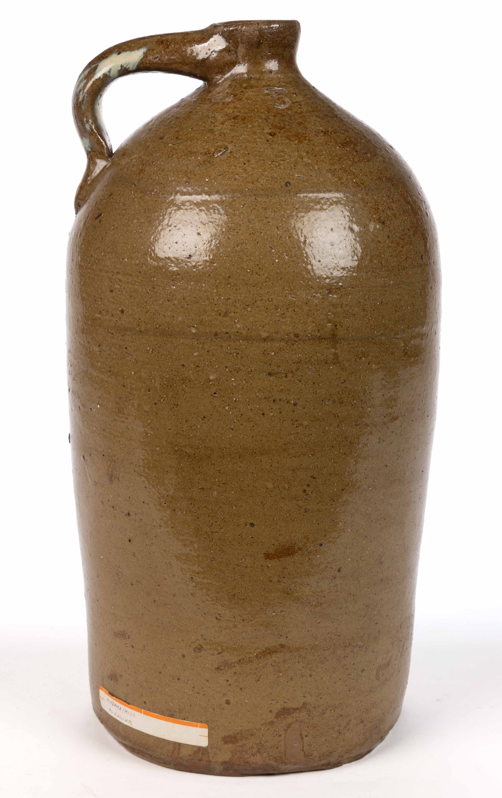 ALABAMA STONEWARE JUG: ALABAMA STONEWARE JUG, alkaline-glazed with rutile streaks on handle, "3" gallon capacity mark, semi-ovoid form with plain mouth and applied strap handle. Fourth quarter 19th century. 16 5/8