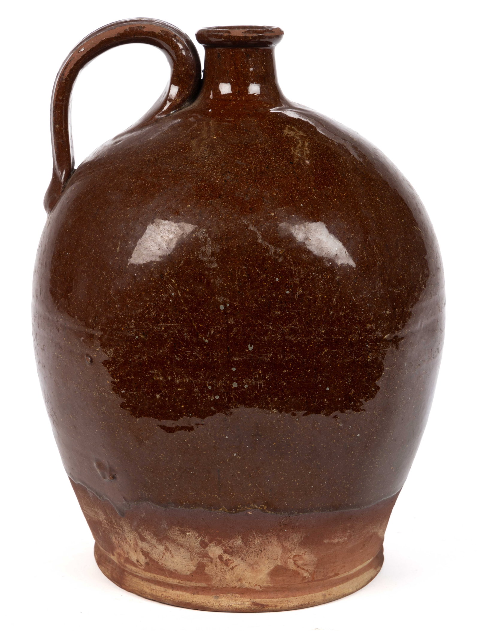 NEW ENGLAND EARTHENWARE / REDWARE JUG: NEW ENGLAND EARTHENWARE / REDWARE JUG, lead-glazed to approximately 2" above base, approximately two-gallon capacity, two flattened sides, rounded mouth, and applied strap handle with low ridges.