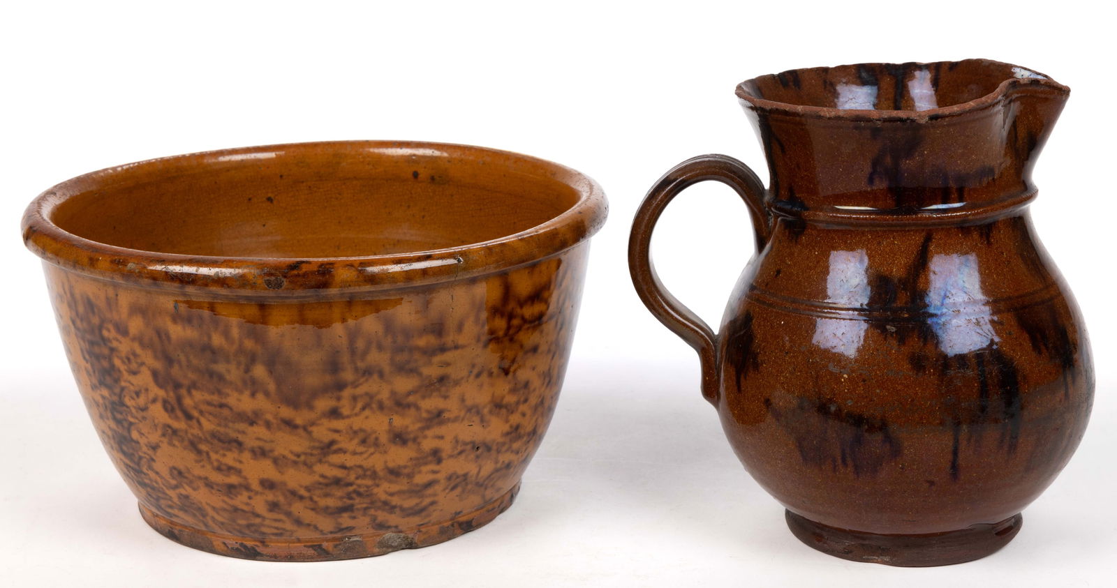 AMERICAN EARTHENWARE / REDWARE DECORATED ARTICLES, LOT OF TWO: AMERICAN EARTHENWARE / REDWARE DECORATED ARTICLES, LOT OF TWO, lead-glazed with manganese splotches or sponging, comprising an 8 3/4" D bowl and a bulbous-form pitcher having applied strap h
