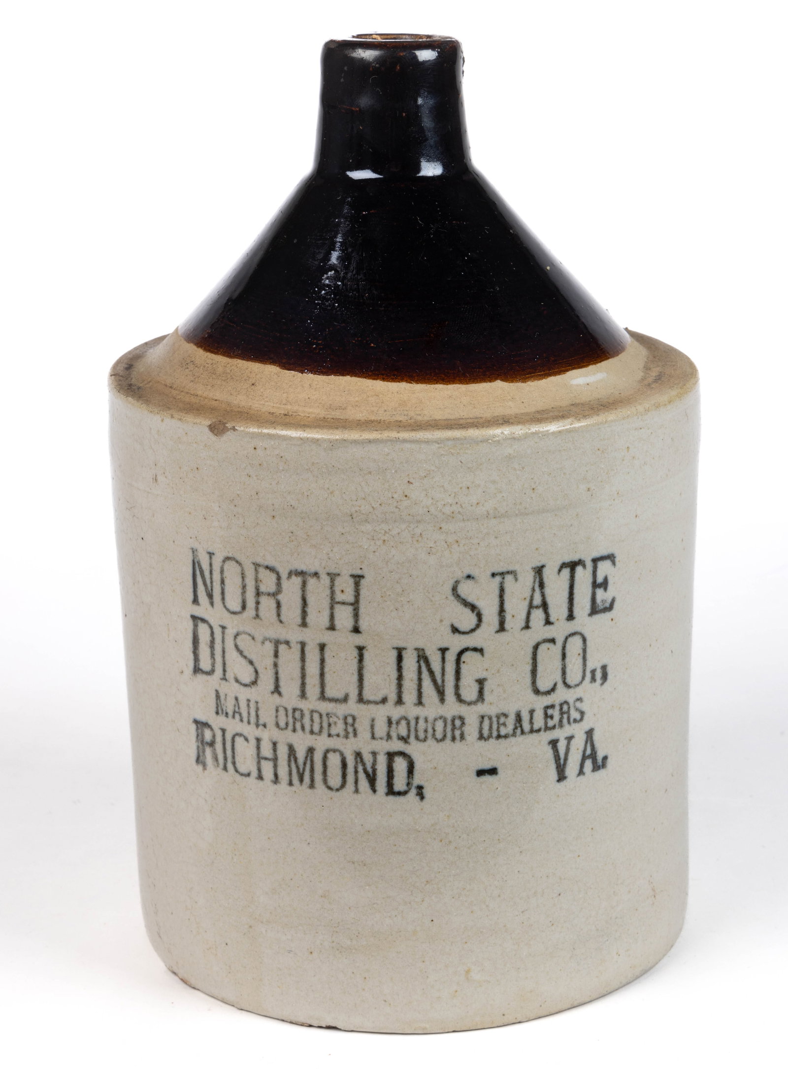 RICHMOND, VIRGINIA MERCHANT'S STONEWARE ADVERTISING JUG: RICHMOND, VIRGINIA MERCHANT'S STONEWARE ADVERTISING JUG, Bristol-slip glazed with Albany-slip glazed upper section, one-gallon capacity, cylindrical form with sharp conical shoulder, plain sp