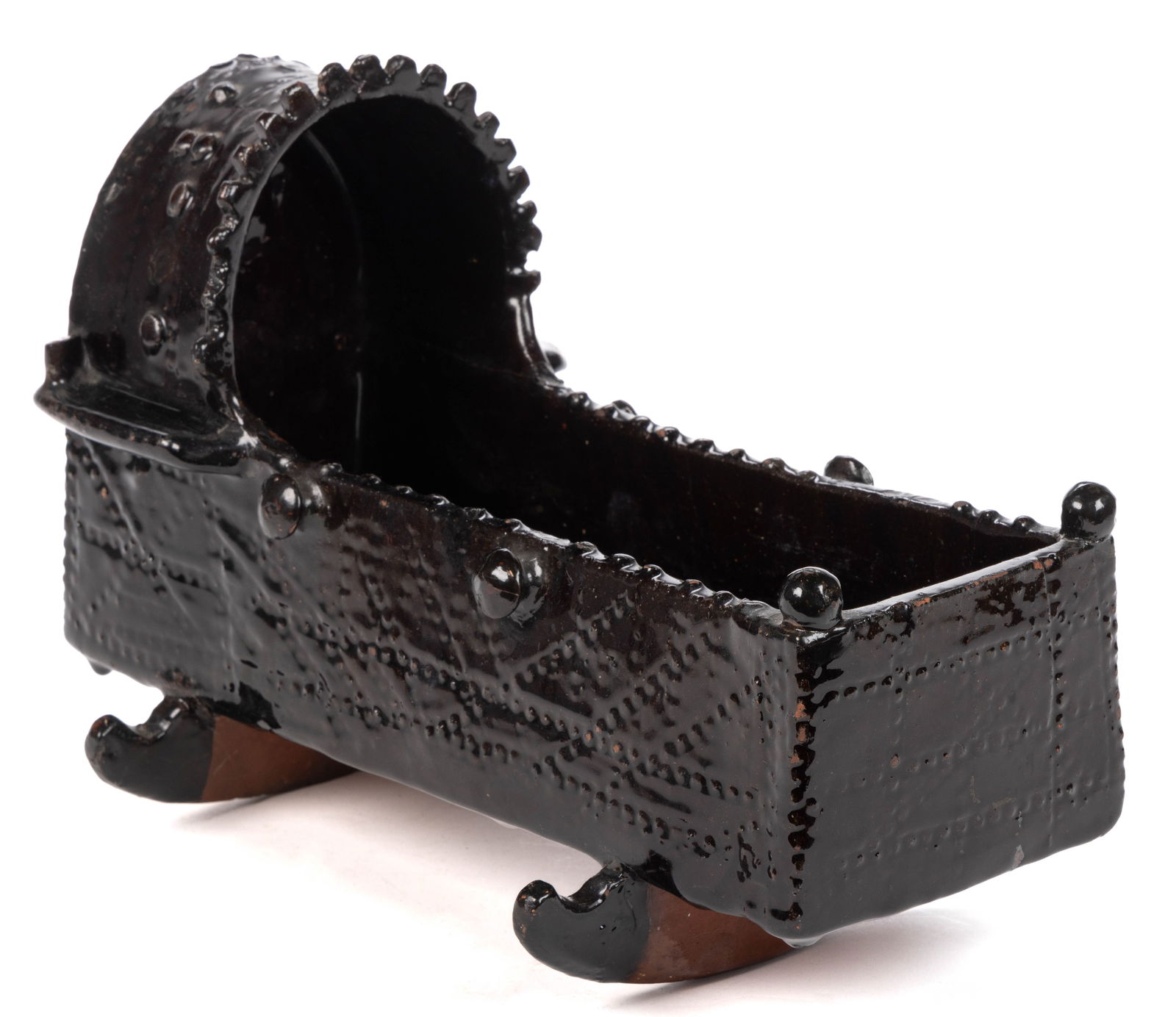 BRITISH EARTHENWARE / REDWARE FIGURAL CRADLE: BRITISH EARTHENWARE / REDWARE FIGURAL CRADLE, dark brown/black-glazed, rectangular form with hood over the bed, molded designs including six protruding knobs to side and end, resting on 