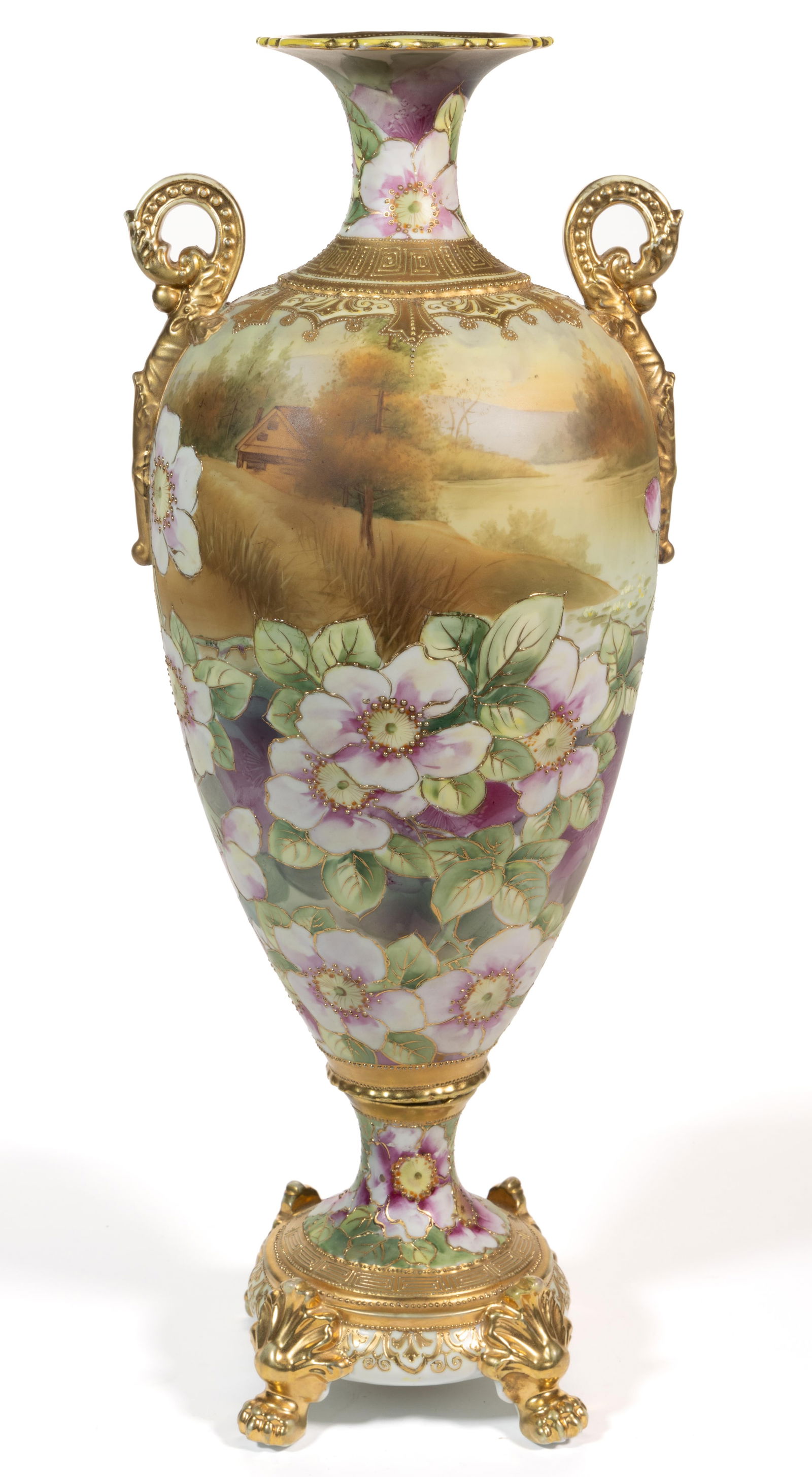 JAPANESE NIPPON PORCELAIN LARGE SCENIC BOLTED URN VASE: JAPANESE NIPPON PORCELAIN LARGE SCENIC BOLTED URN VASE, two-piece construction, tapered ovoid form with elaborately molded paw-footed base and scrolled handles, having polychrome decorations depicting
