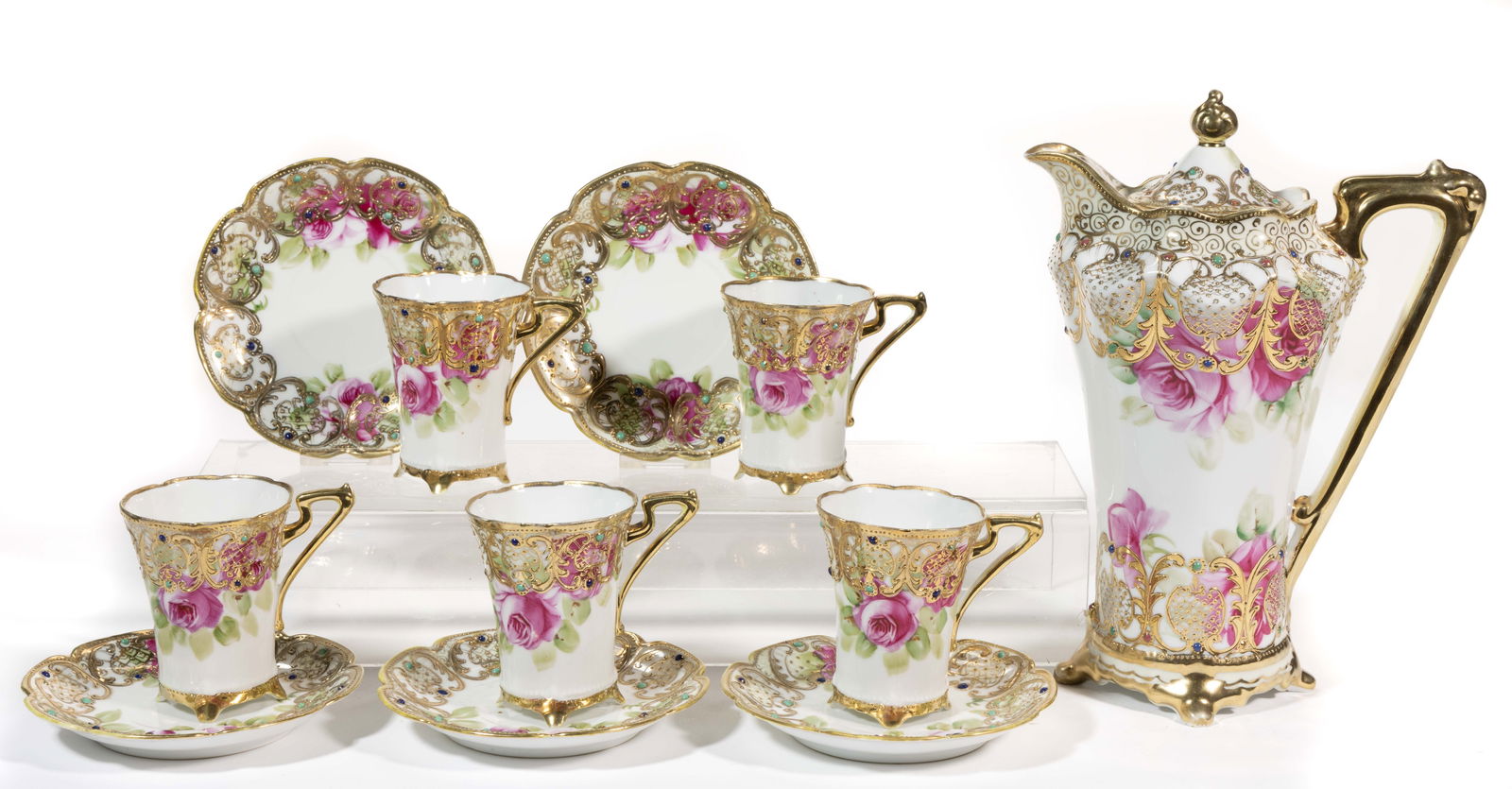 JAPANESE NIPPON PORCELAIN 11-PIECE CHOCOLATE SET: JAPANESE NIPPON PORCELAIN 11-PIECE CHOCOLATE SET, each having pink hand-painted rose decoration with raised gilt and polychrome enamel jewelled decorations, comprising a chocolate pot and five cup and