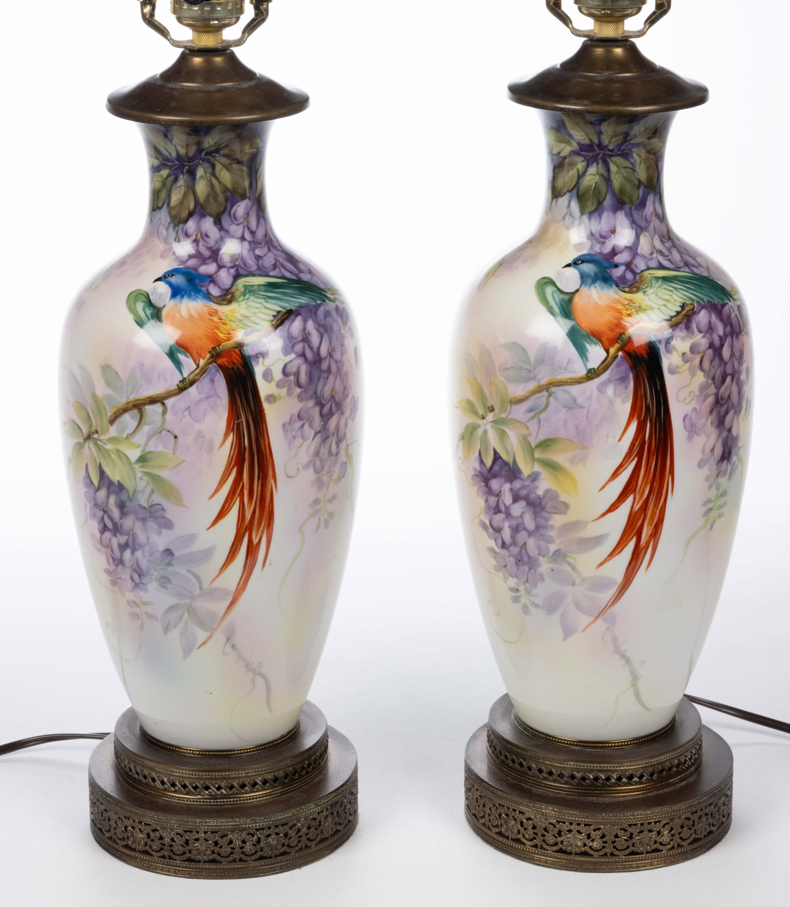 CONTINENTAL / JAPANESE PORCELAIN HAND-PAINTED BIRD MOTIF LAMP PAIR: CONTINENTAL / JAPANESE PORCELAIN HAND-PAINTED BIRD MOTIF LAMP PAIR, baluster form, each having bright polychrome decorations featuring a long-tailed bird of paradise perched on a wisteria branch. Late