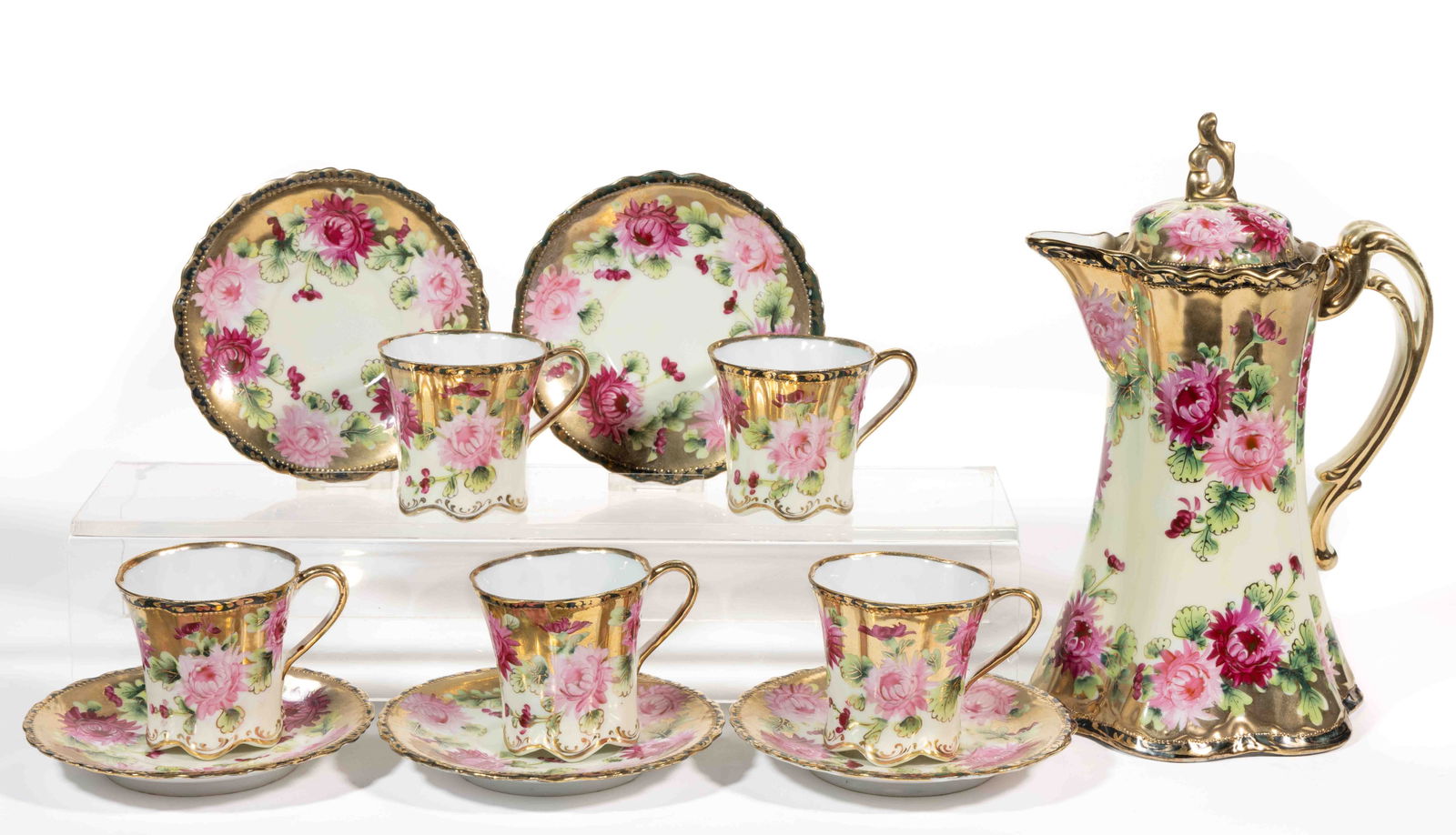 JAPANESE NIPPON PORCELAIN 11-PIECE CHOCOLATE SET: JAPANESE NIPPON PORCELAIN 11-PIECE CHOCOLATE SET, each having polychrome hand-painted floral designs on cream ground with gilt decorations, comprising a chocolate pot and five cup and saucer sets. Pot
