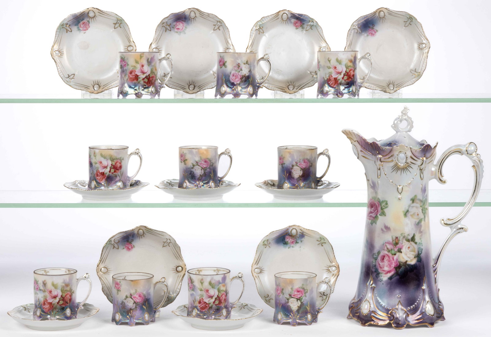 R.S. PRUSSIA PORCELAIN FLORAL MOTIF 22-PIECE CHOCOLATE SET: R.S. PRUSSIA PORCELAIN FLORAL MOTIF 22-PIECE CHOCOLATE SET, RSP Mold 18, each having polychrome transfer rose design with dark purple to lower half, opal jewel decorations, and satin finish, comprisin