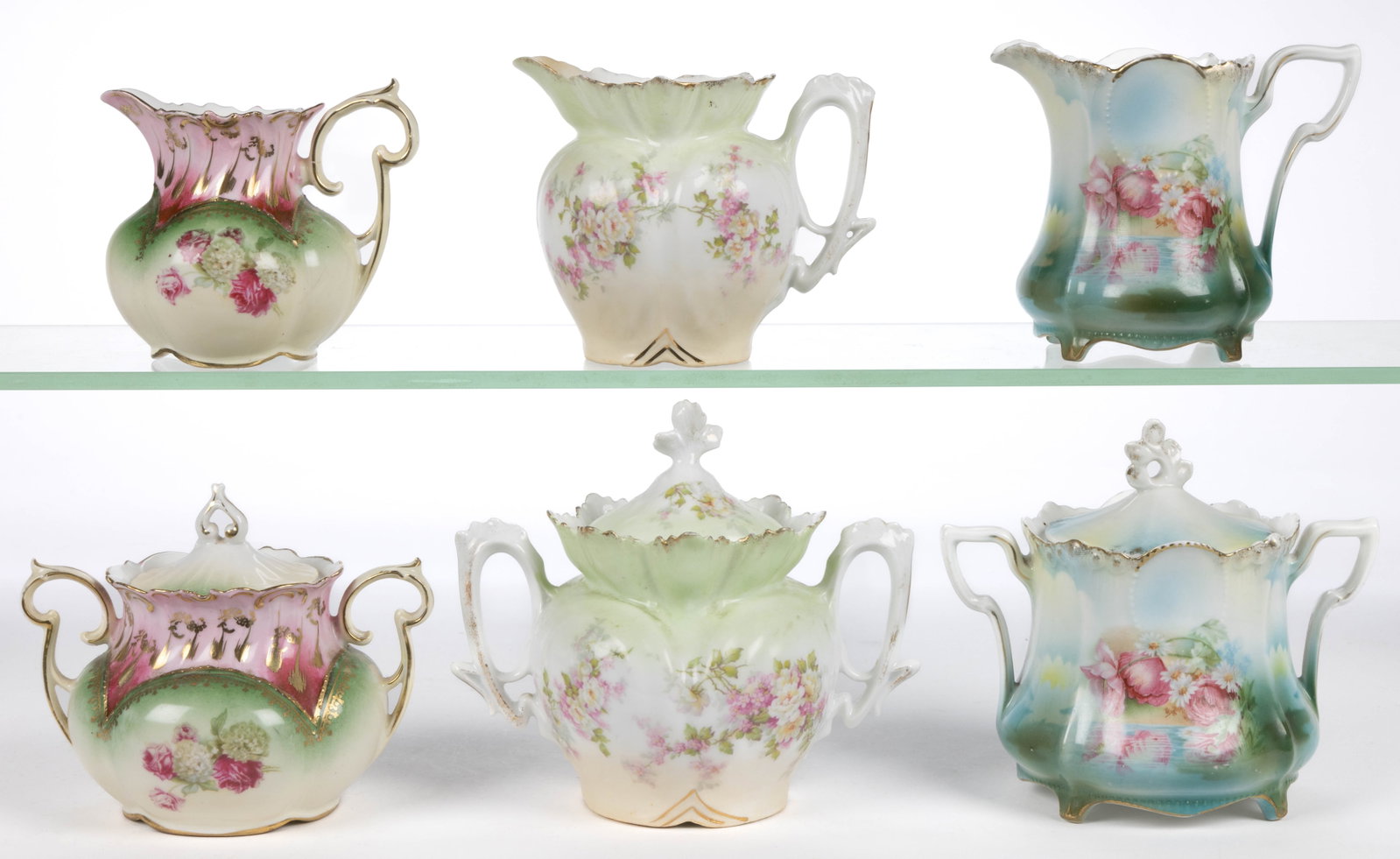 R.S. PRUSSIA PORCELAIN FLORAL MOTIF TEA ARTICLES, LOT OF SIX: R.S. PRUSSIA PORCELAIN FLORAL MOTIF TEA ARTICLES, LOT OF SIX, comprising three matching sets including a covered sugar and creamer with polychrome transfer decorations, including one RSP Mold 14 set f