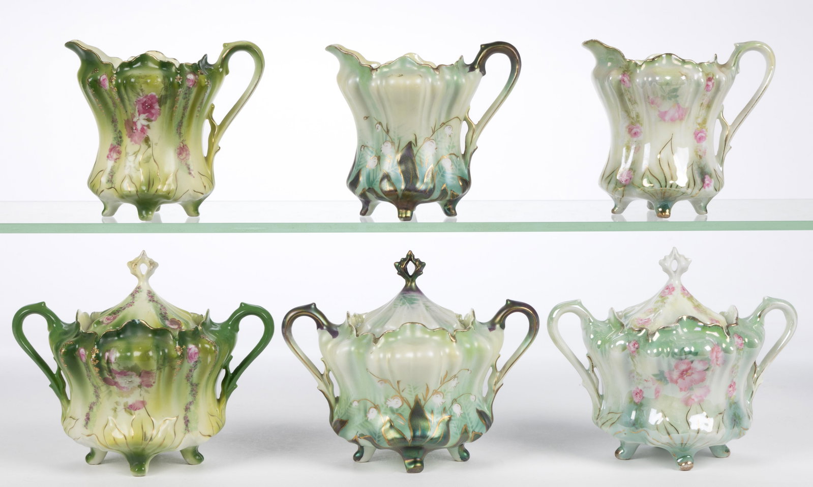 R.S. PRUSSIA PORCELAIN FLORAL MOTIF TEA ARTICLES, LOT OF SIX: R.S. PRUSSIA PORCELAIN FLORAL MOTIF TEA ARTICLES, LOT OF SIX, RSP Mold 703, comprising three four-footed matching sets that include a covered sugar and a creamer having polychrome transfer decorations