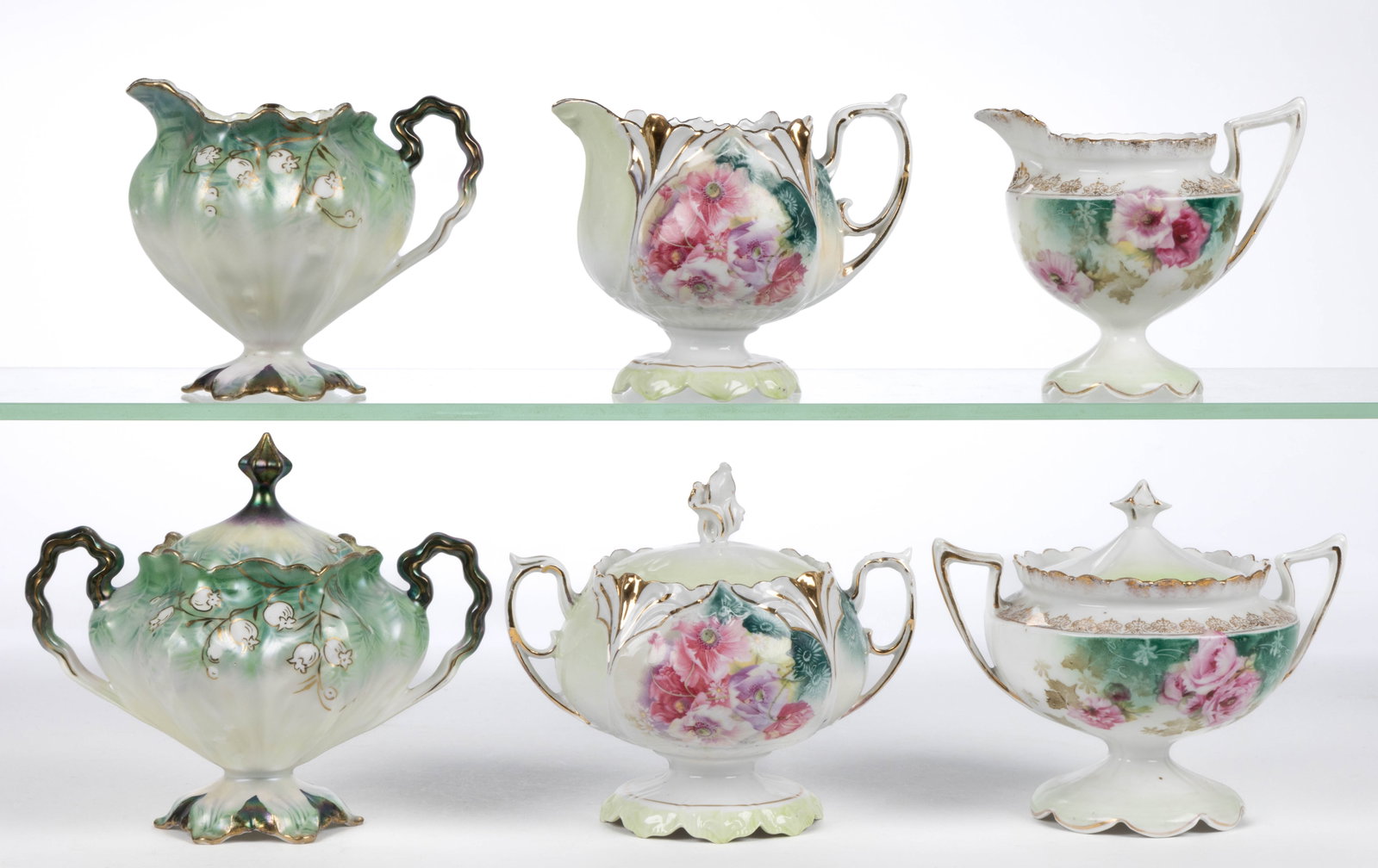 R.S. PRUSSIA PORCELAIN FLORAL MOTIF TEA ARTICLES, LOT OF SIX: R.S. PRUSSIA PORCELAIN FLORAL MOTIF TEA ARTICLES, LOT OF SIX, comprising three matching sets that include a pedestal-form covered sugar and creamer, each having polychrome transfer decorations with gi