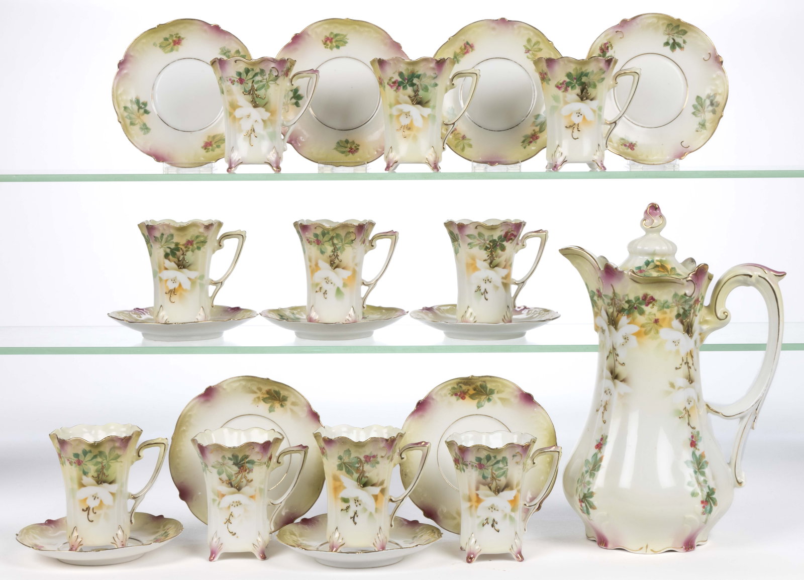 R.S. PRUSSIA PORCELAIN FLORAL MOTIF 21-PIECE CHOCOLATE SET: R.S. PRUSSIA PORCELAIN FLORAL MOTIF 21-PIECE CHOCOLATE SET, each having polychrome transfer featuring white flowers and a leafy vine laden with red berries and gilt accents, comprising a chocolate pot