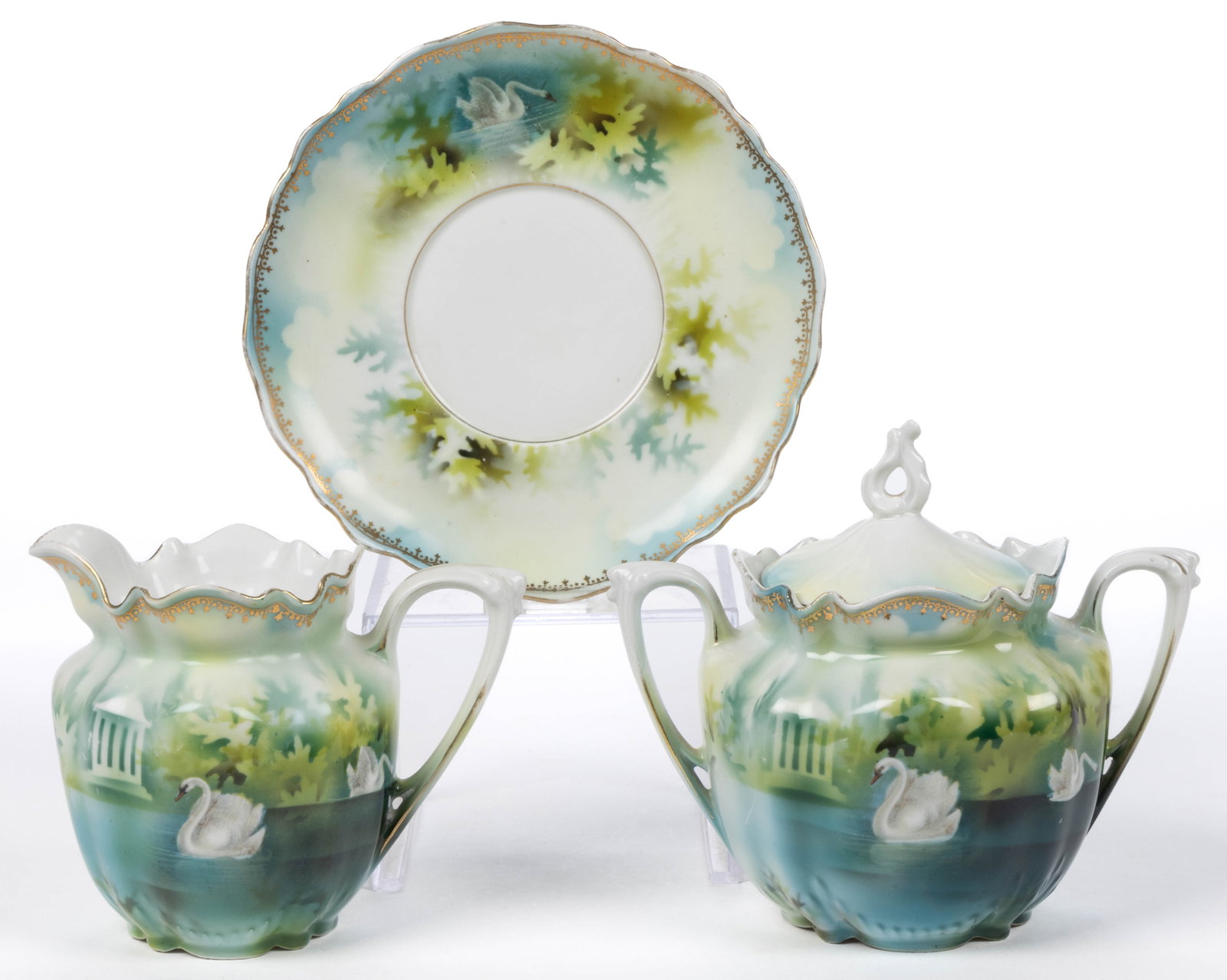 R.S. PRUSSIA PORCELAIN SWAN MOTIF TEA ARTICLES, LOT OF THREE: R.S. PRUSSIA PORCELAIN SWAN MOTIF TEA ARTICLES, LOT OF THREE, RSP Mold 508, comprising a covered sugar and creamer with saucer having polychrome transfer image featuring two swans on serene water with