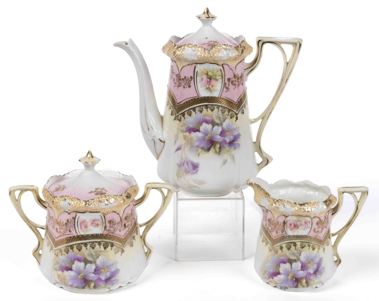 R.S. PRUSSIA PORCELAIN FLORAL MOTIF THREE-PIECE TEA SET: R.S. PRUSSIA PORCELAIN FLORAL MOTIF THREE-PIECE TEA SET, RSP Mold 23, each having beautiful purple flower transfer with rose medallion above on a pink band, and gilt accents, comprising a teapot, a co