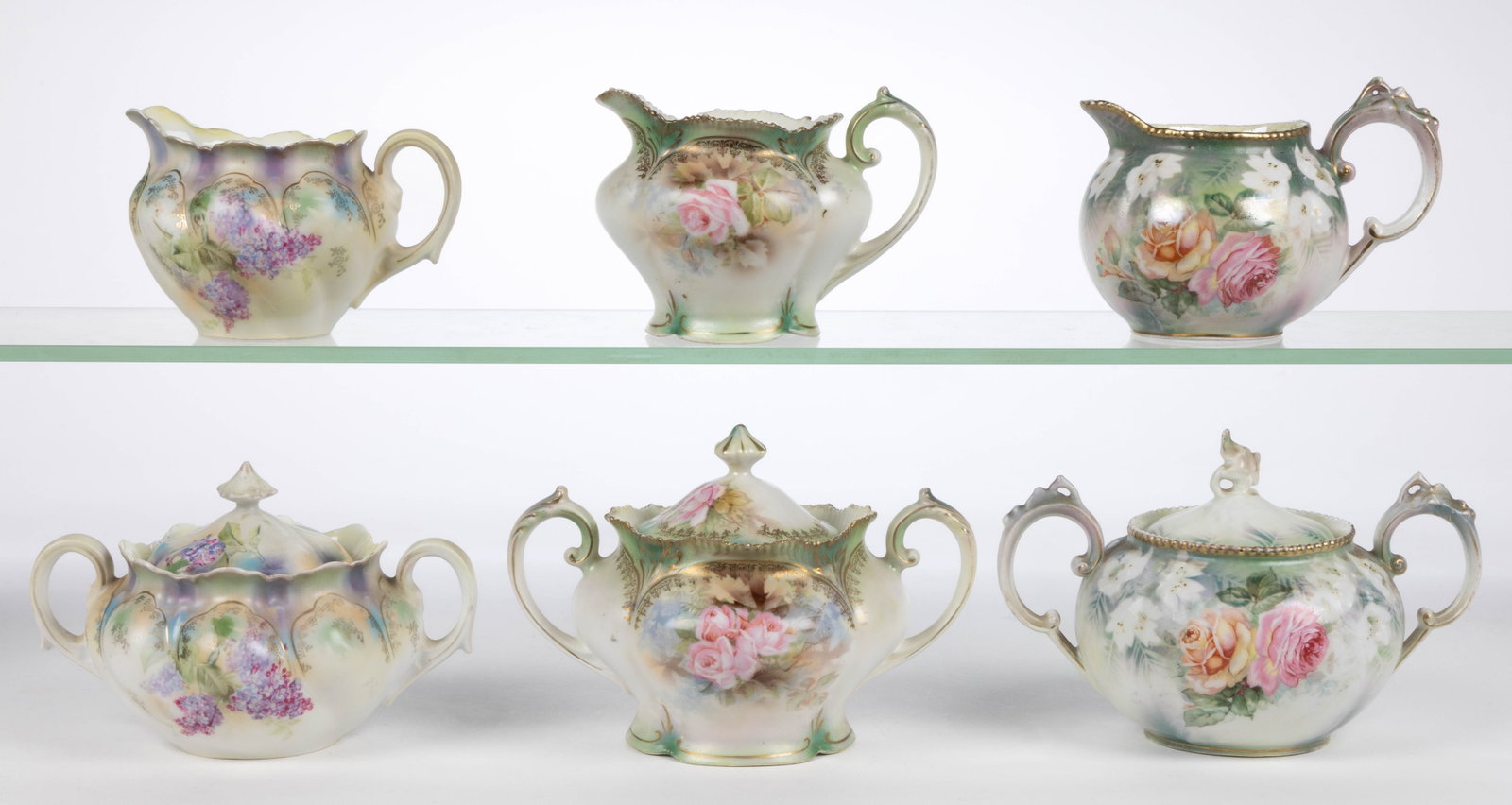 R.S. PRUSSIA PORCELAIN FLORAL MOTIF TEA ARTICLES, LOT OF SIX: R.S. PRUSSIA PORCELAIN FLORAL MOTIF TEA ARTICLES, LOT OF SIX, comprising three matching sets including a covered sugar and creamer with polychrome transfer decorations and satin finish, including one 