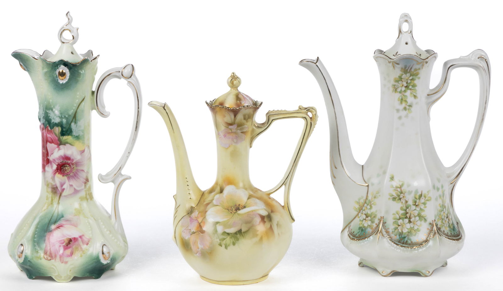 R.S. PRUSSIA PORCELAIN FLORAL MOTIF DEMITASSE POTS, LOT OF THREE: R.S. PRUSSIA PORCELAIN FLORAL MOTIF DEMITASSE POTS, LOT OF THREE, each having polychrome transfer designs with gilt accents, comprising one satin finish panel-form example with beaded drape design abo