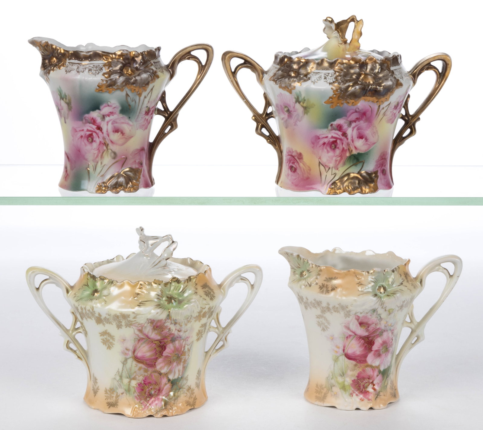 R.S. PRUSSIA PORCELAIN FLORAL MOTIF TEA ARTICLES, LOT OF FOUR: R.S. PRUSSIA PORCELAIN FLORAL MOTIF TEA ARTICLES, LOT OF FOUR, RSP Mold 28, comprising two matching creamer and covered sugar sets having molded carnation design to rim and base with polychrome and gi