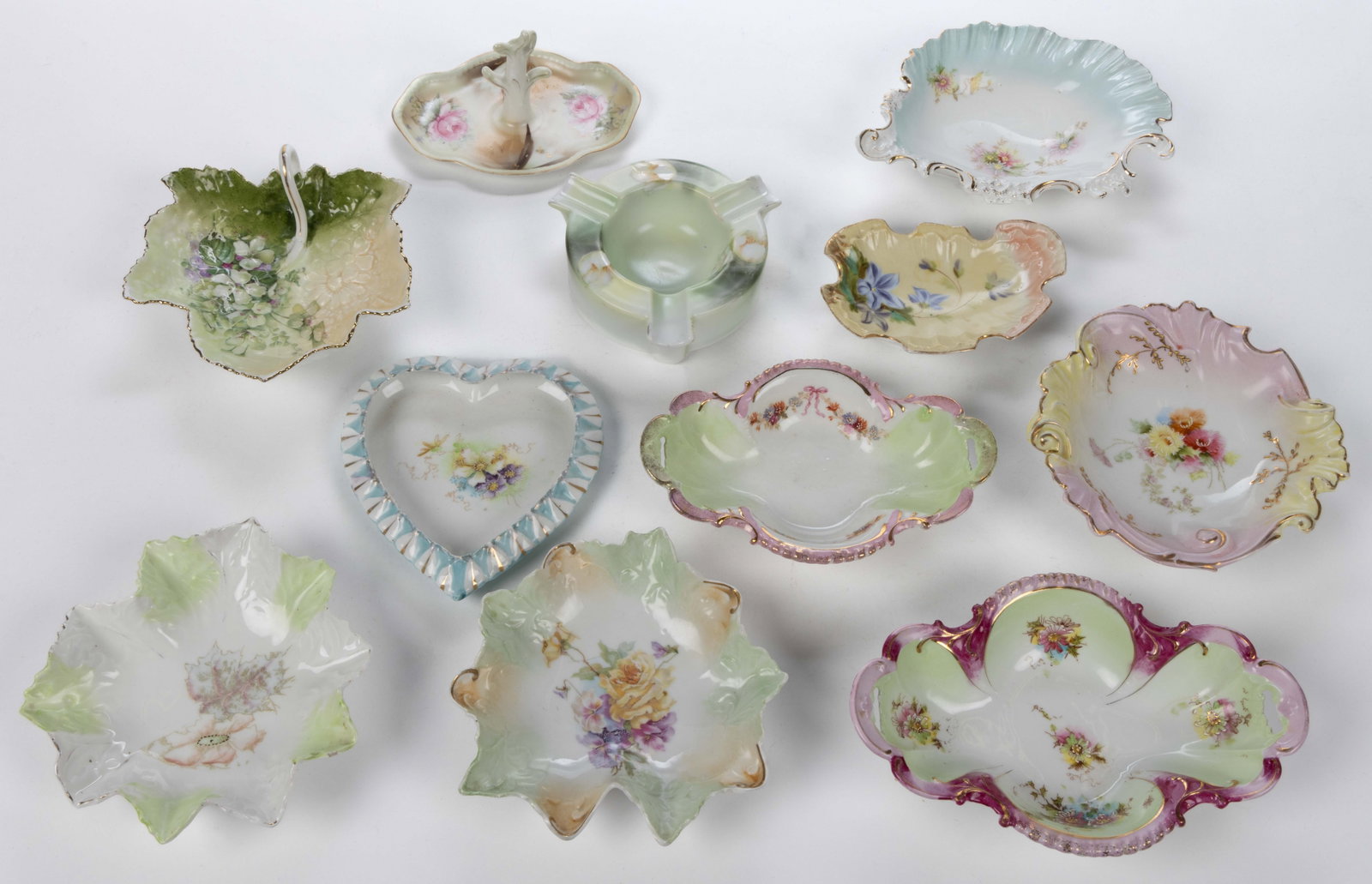 R.S. PRUSSIA / GERMANY PORCELAIN FLORAL MOTIF ARTICLES, LOT OF 11: R.S. PRUSSIA / GERMANY PORCELAIN FLORAL MOTIF ARTICLES, LOT OF 11, including an ashtray, a ring holder, two quatrefoil-shaped dishes with open handles, a heart-shaped dish, one shell-form example with