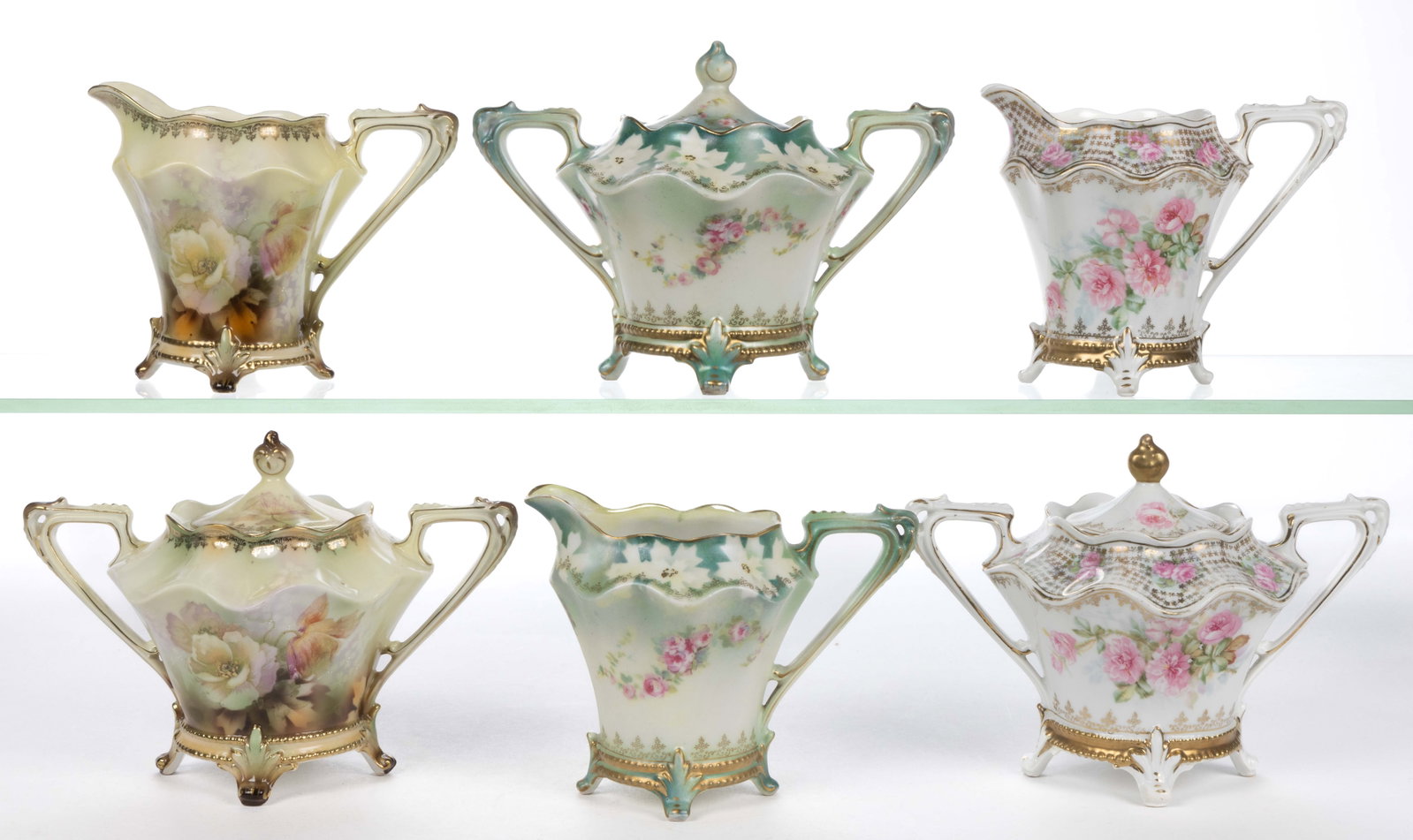 R.S. PRUSSIA PORCELAIN FLORAL MOTIF TEA ARTICLES, LOT OF SIX: R.S. PRUSSIA PORCELAIN FLORAL MOTIF TEA ARTICLES, LOT OF SIX, RSP Mold 704, comprising three matching creamer and covered sugar sets with "fleur-de-lys" feet having polychrome and gilt transfer decora