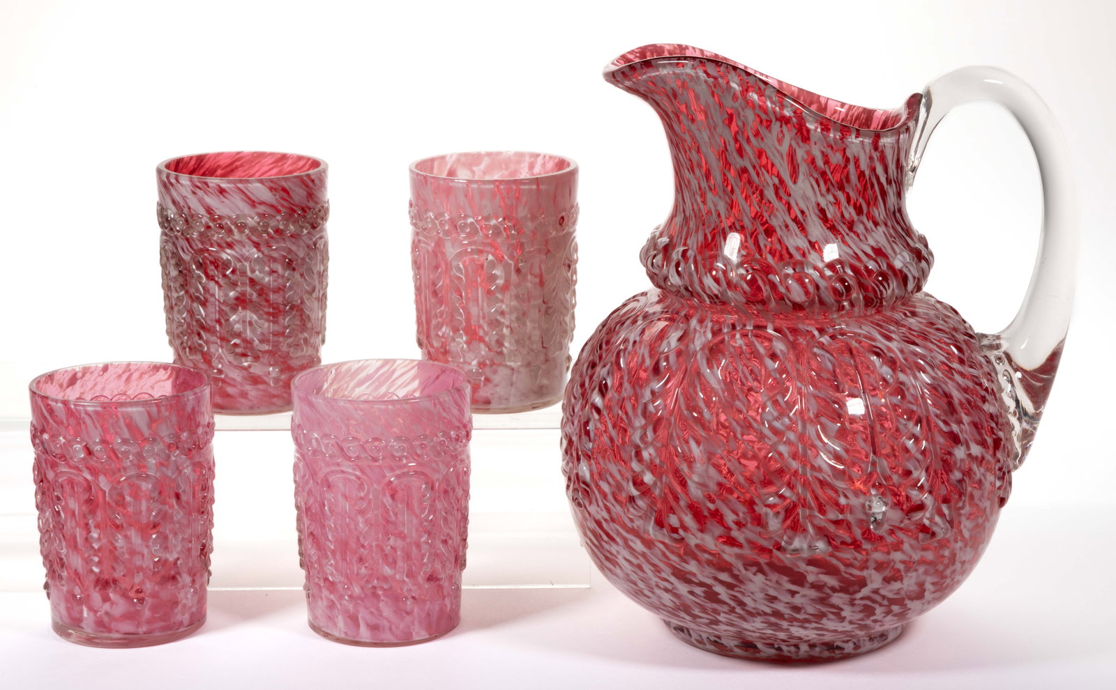 NORTHWOOD NO. 263 / LEAF UMBRELLA FIVE-PIECE WATER SET: NORTHWOOD NO. 263 / LEAF UMBRELLA FIVE-PIECE WATER SET, cased Ruby with opal spatter, comprising a water pitcher and four tumblers. Northwood Glass Co. Pattern introduced in 1889. Pitcher: 9" H. Tumbl