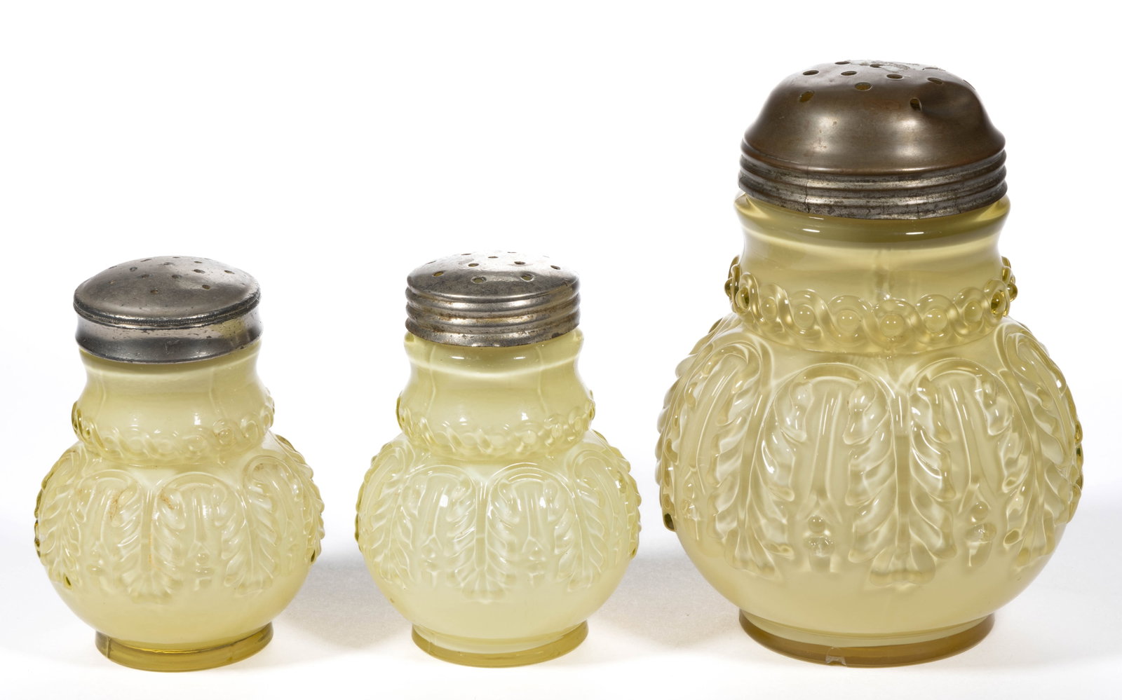 NORTHWOOD NO. 263 / LEAF UMBRELLA CONDIMENT ARTICLES, LOT OF THREE: NORTHWOOD NO. 263 / LEAF UMBRELLA CONDIMENT ARTICLES, LOT OF THREE, Topaz, comprising a sugar shaker, and a salt and pepper shaker, each having a period lid. Northwood Glass Co. Pattern introduced in 
