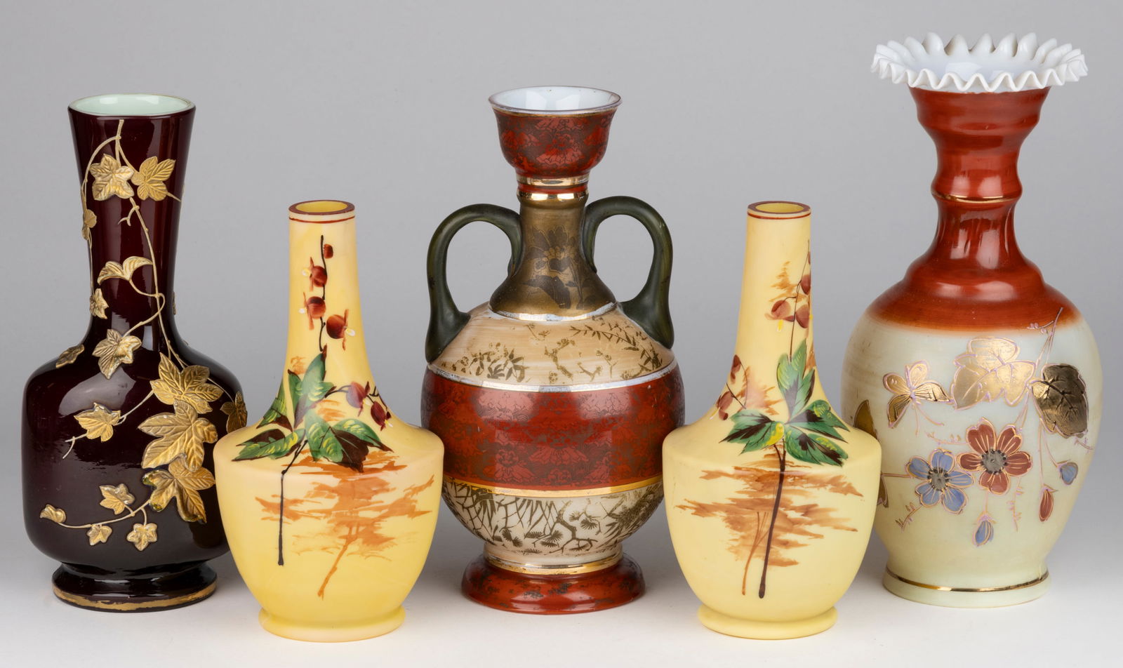 ASSORTED VICTORIAN DECORATED VASES, LOT OF FIVE: ASSORTED VICTORIAN DECORATED VASES, LOT OF FIVE, including an opal-cased deep red example with gilt impasto vine decoration and faux Webb mark; and a pair with polychrome-enamel foliate decoration. Fo