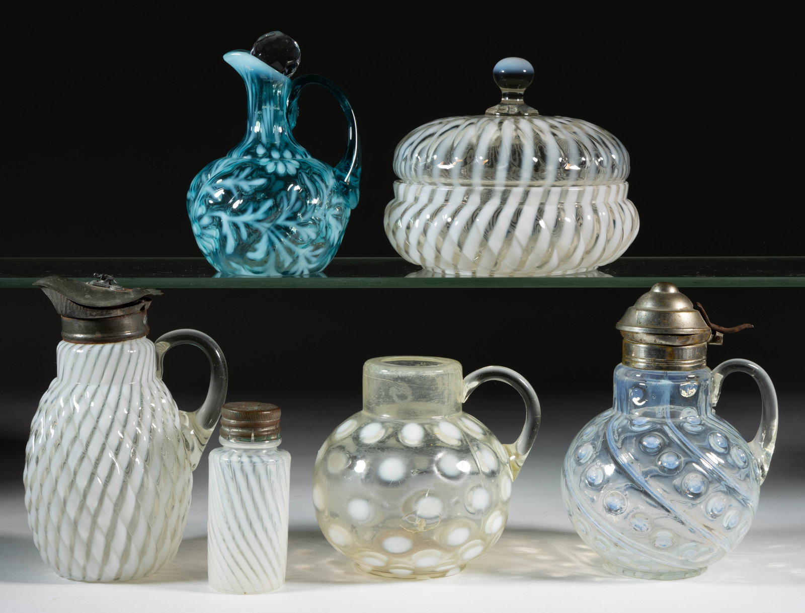 ASSORTED BLOWN OPALESCENT GLASS ARTICLES, LOT OF SIX: ASSORTED BLOWN OPALESCENT GLASS ARTICLES, LOT OF SIX, colorless and blue, each being opalescent, including a Reverse Swirl syrup pitcher and covered butter dish, a Daisy and Fern cruet with an ill-fit
