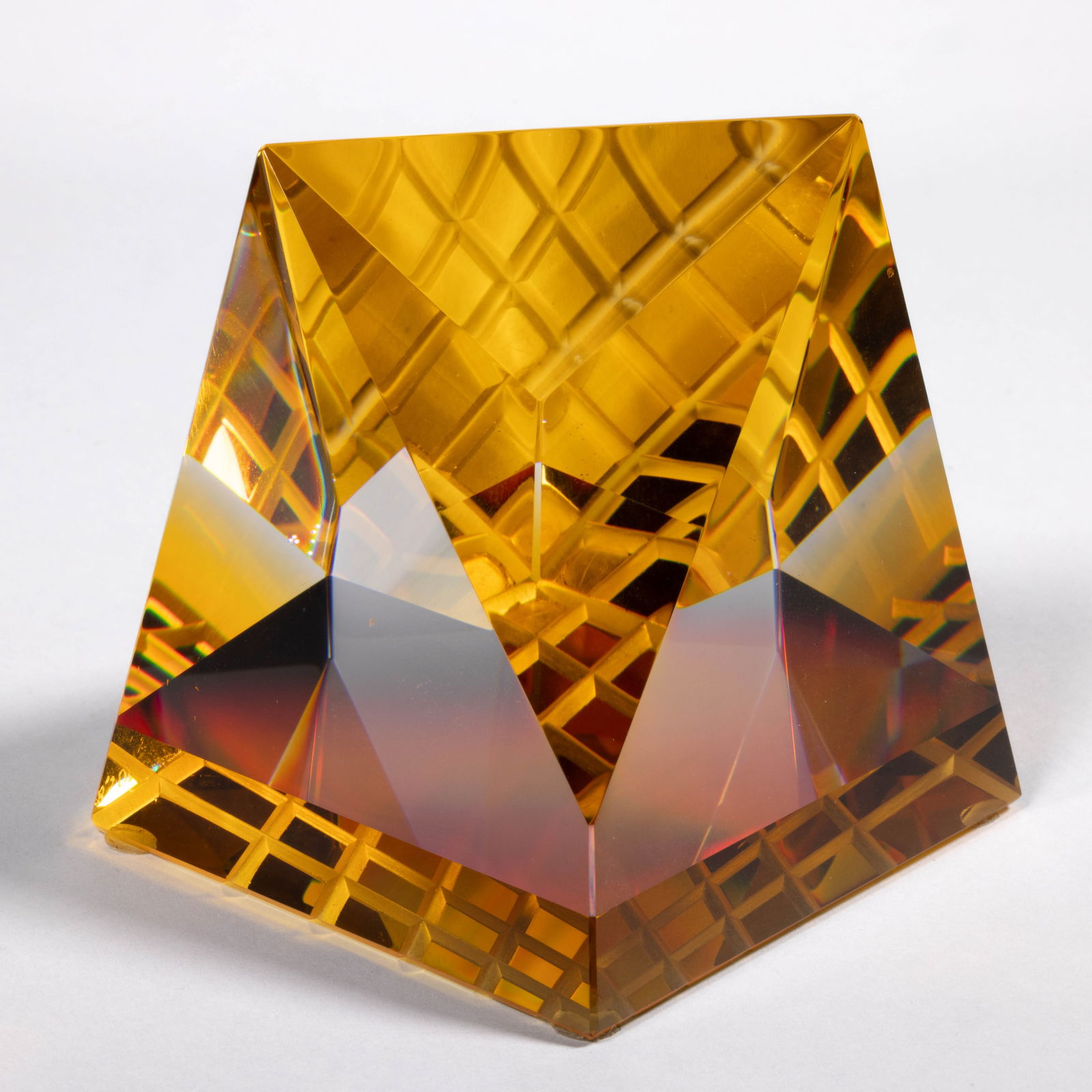 JAMES SHAW (AMERICAN, B. 1953) SPACE CUBE OPTICAL CUT STUDIO ART GLASS PAPERWEIGHT: JAMES SHAW (AMERICAN, B. 1953) SPACE CUBE OPTICAL CUT STUDIO ART GLASS PAPERWEIGHT, colorless top with amber base with the optics making it seem completely amber at certain angles, geometric cuts with