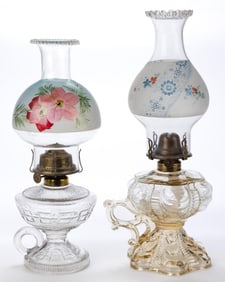 ASSORTED PATTERN KEROSENE FOOTED FINGER LAMPS, LOT OF TWO