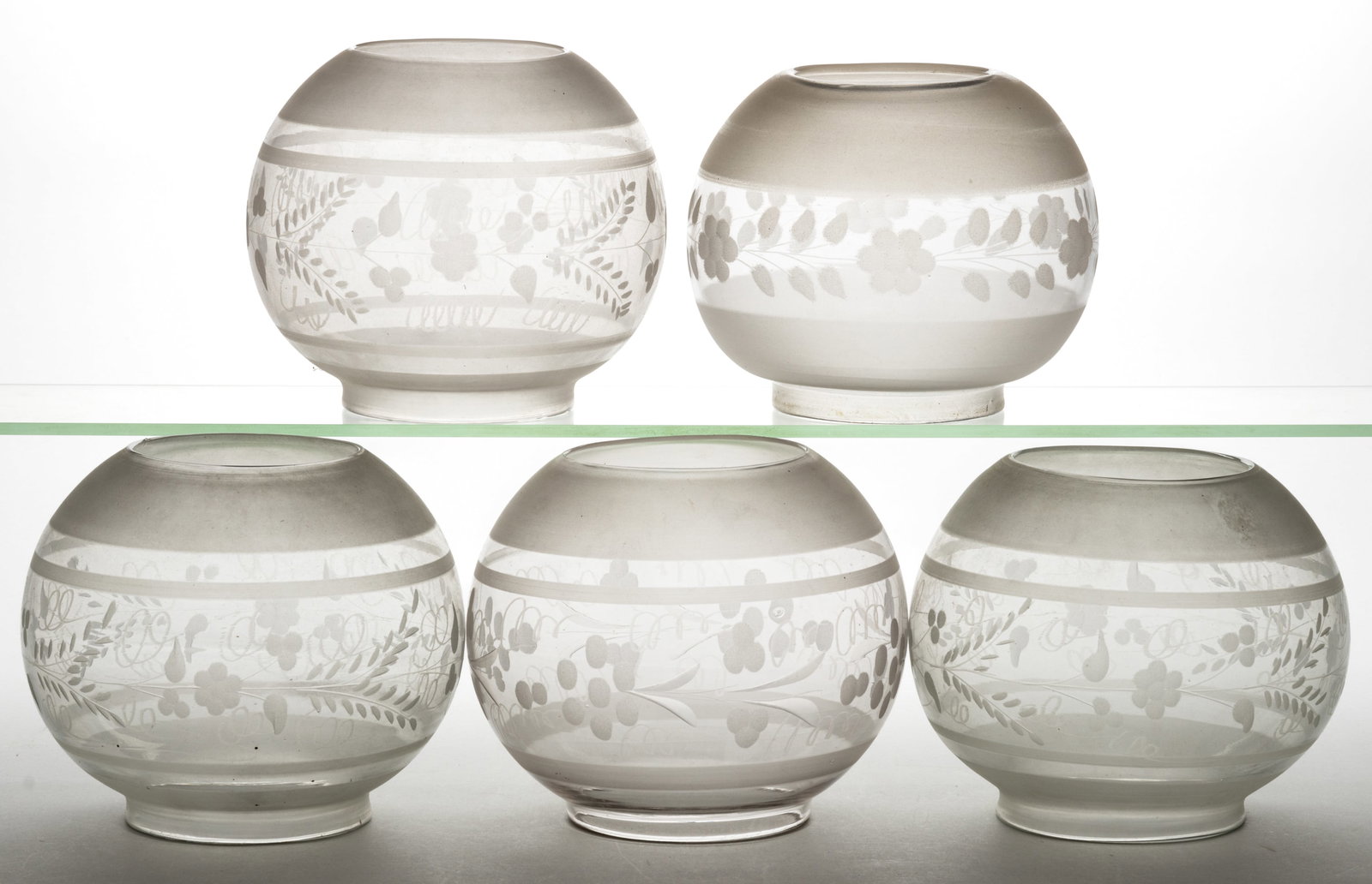 ASSORTED BLOWN ENGRAVED LAMP SHADES, LOT OF FIVE: ASSORTED BLOWN ENGRAVED LAMP SHADES, LOT OF FIVE, colorless with frosted finish, each of globular form with various stylized foliage and berry patterns, including three matching patterned examples. Fo