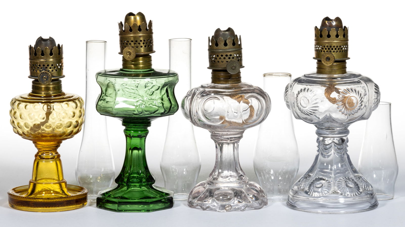 ASSORTED PATTERNED KEROSENE MINIATURE STAND LAMPS, LOT OF FOUR: ASSORTED PATTERNED KEROSENE MINIATURE STAND LAMPS, LOT OF FOUR, colorless, amber, and moss green, patterns comprising of a Daisy/Smith I, fig. 112 example; Riverside Rose/Smith I, fig. 114; a Smith I,