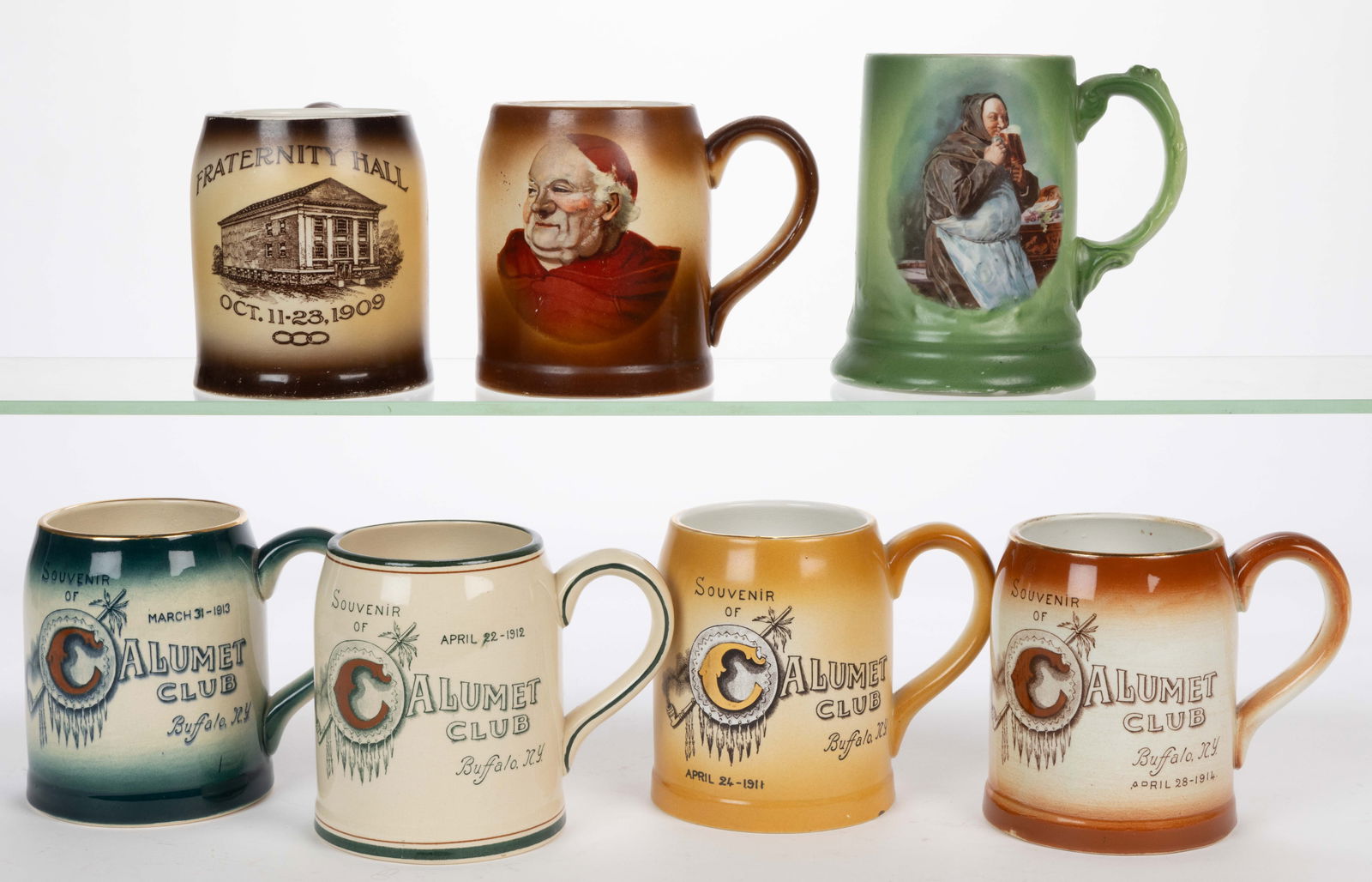 BUFFALO POTTERY TRANSFER-DECORATED ADVERTISING MUGS, LOT OF SEVEN: BUFFALO POTTERY TRANSFER-DECORATED ADVERTISING MUGS, LOT OF SEVEN, comprising four examples having "SOUVENIR / OF / CALUMET / CLUB / Buffalo, N.Y." with various dates and colors, one example