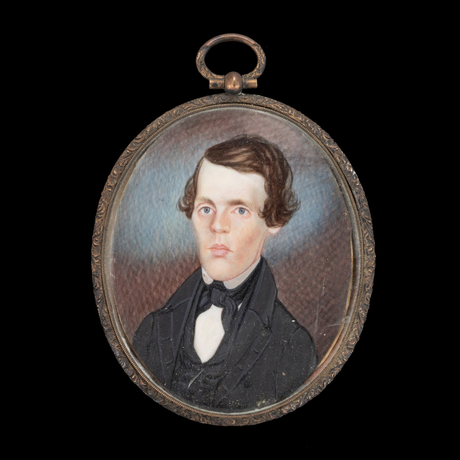 AMERICAN OR ENGLISH SCHOOL (19TH CENTURY) MINIATURE PORTRAIT OF A GENTLEMAN: AMERICAN OR ENGLISH SCHOOL (19TH CENTURY) MINIATURE PORTRAIT OF A GENTLEMAN, watercolor, a bust-length depiction of a blue-eyed man dressed in a dark jacket with a high collar. Housed under convex gla