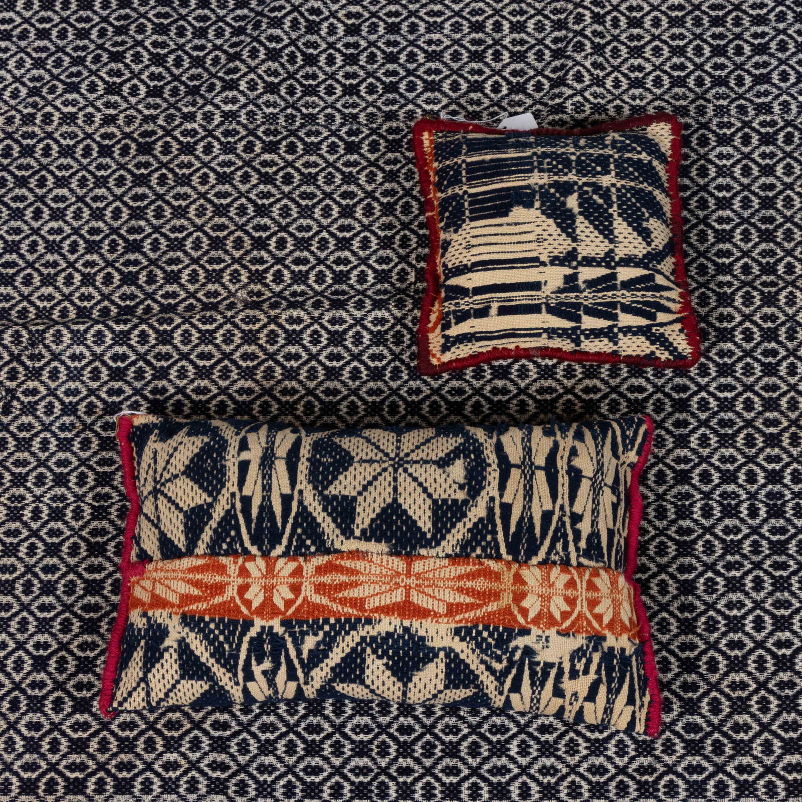 MID-ATLANTIC OVERSHOT COVERLET: MID-ATLANTIC OVERSHOT COVERLET, dark blue wool and natural cotton, three joined panels, having overall geometric pattern, lower corners later hemmed to be rounded. Together with two pillows made from