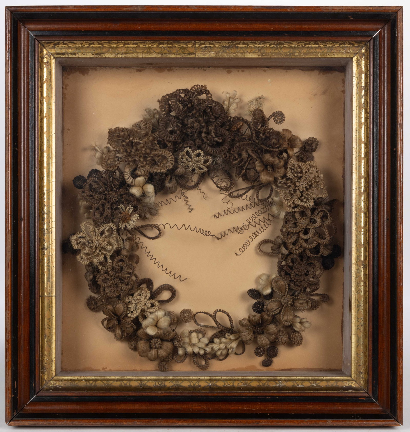 VICTORIAN WOVEN HAIR MOURNING WREATH: VICTORIAN WOVEN HAIR MOURNING WREATH, various shades of hair intricately woven on metal wire frame, featuring flowers in a wreath arrangement. Housed under glass in a probably original shadow box fram