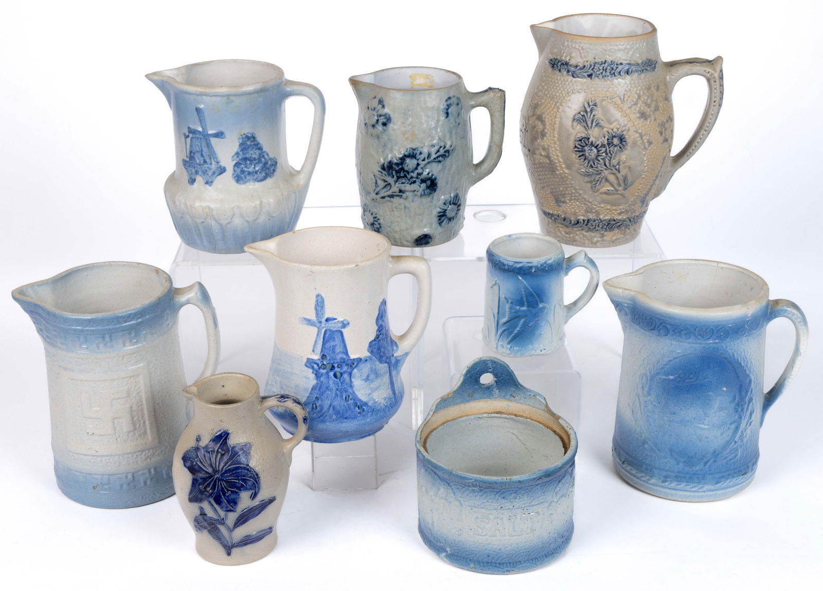 AMERICAN BLUE AND WHITE STONEWARE KITCHEN ARTICLES, LOT OF NINE: AMERICAN BLUE AND WHITE STONEWARE KITCHEN ARTICLES, LOT OF NINE, comprising a salt crock with apricots motif lacking a cover, a mug with embossed flying bird design, and seven pitchers including
