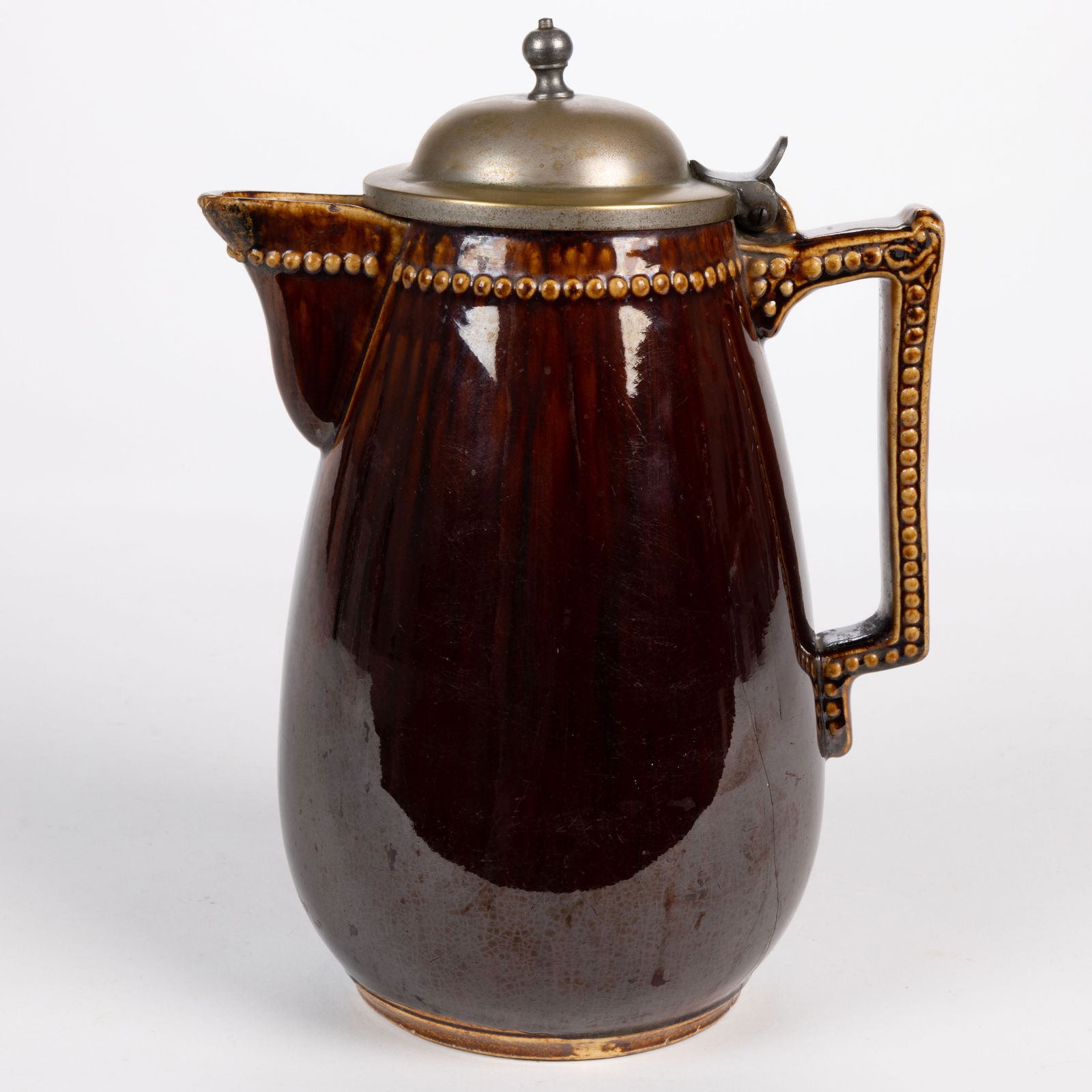 J. E. JEFFORDS & CO., PHILADELPHIA ATTRIBUTED ROCKINGHAM-GLAZED POTTERY CHOCOLATE POT: J. E. JEFFORDS & CO., PHILADELPHIA ATTRIBUTED ROCKINGHAM-GLAZED POTTERY CHOCOLATE POT, brown glaze over yellowware body, molded semi-ovoid form with circular beaded designs around spout and b
