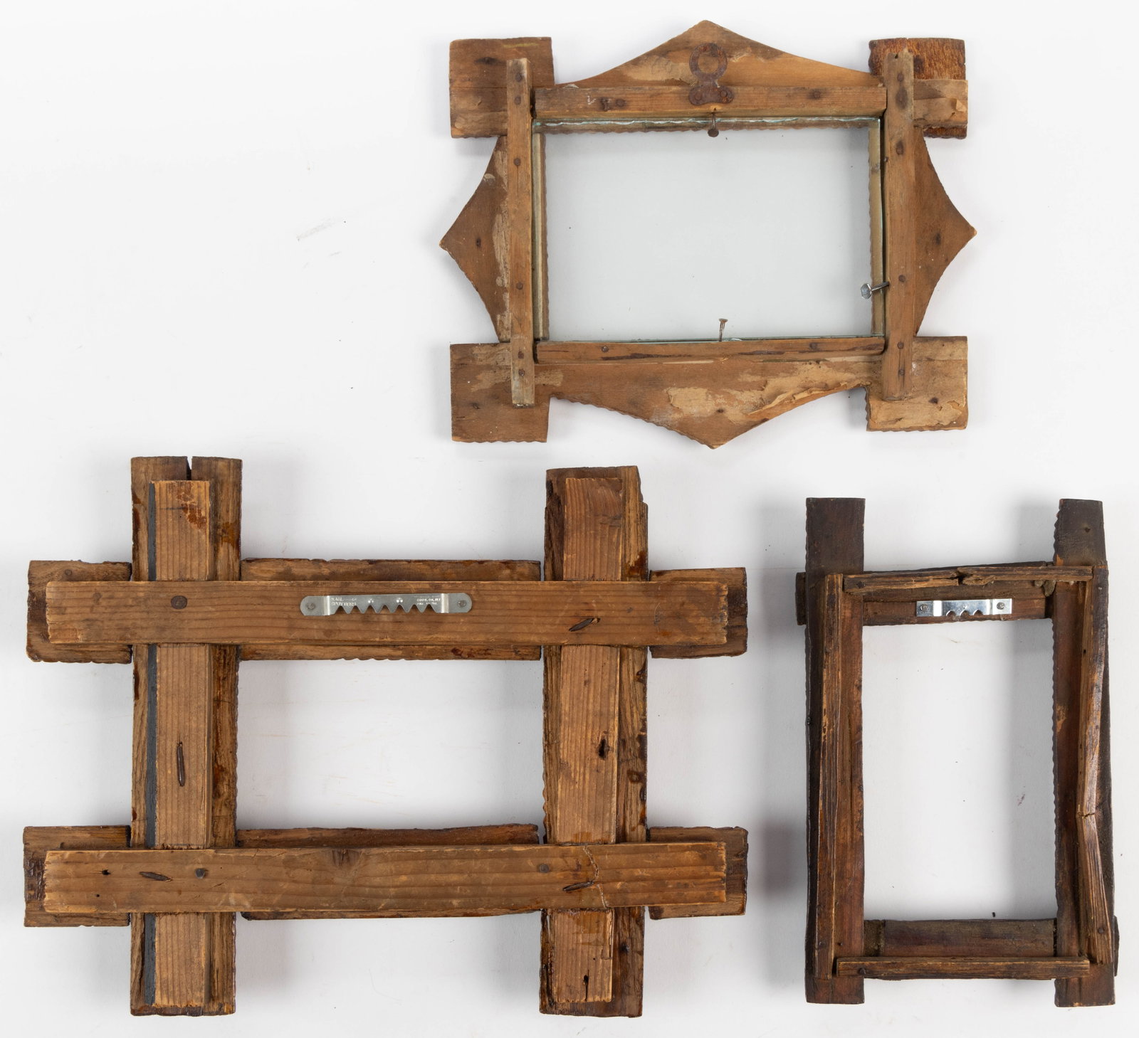 AMERICAN FOLK / TRAMP ART PICTURE FRAMES, LOT OF THREE: AMERICAN FOLK / TRAMP ART PICTURE FRAMES, LOT OF THREE, of finely executed form with notch-carved stacked designs with sawtooth edge profiles, the smallest with two circular decorations on the extende