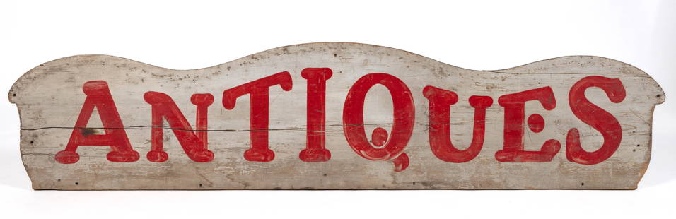 AMERICAN FOLK ART "ANTIQUES" PAINTED WOODEN TRADE SIGN: AMERICAN FOLK ART "ANTIQUES" PAINTED WOODEN TRADE SIGN, painted poplar, featuring "ANTIQUES" painted in red lettering on a white ground. Likely the back of a sofa or similar uphols