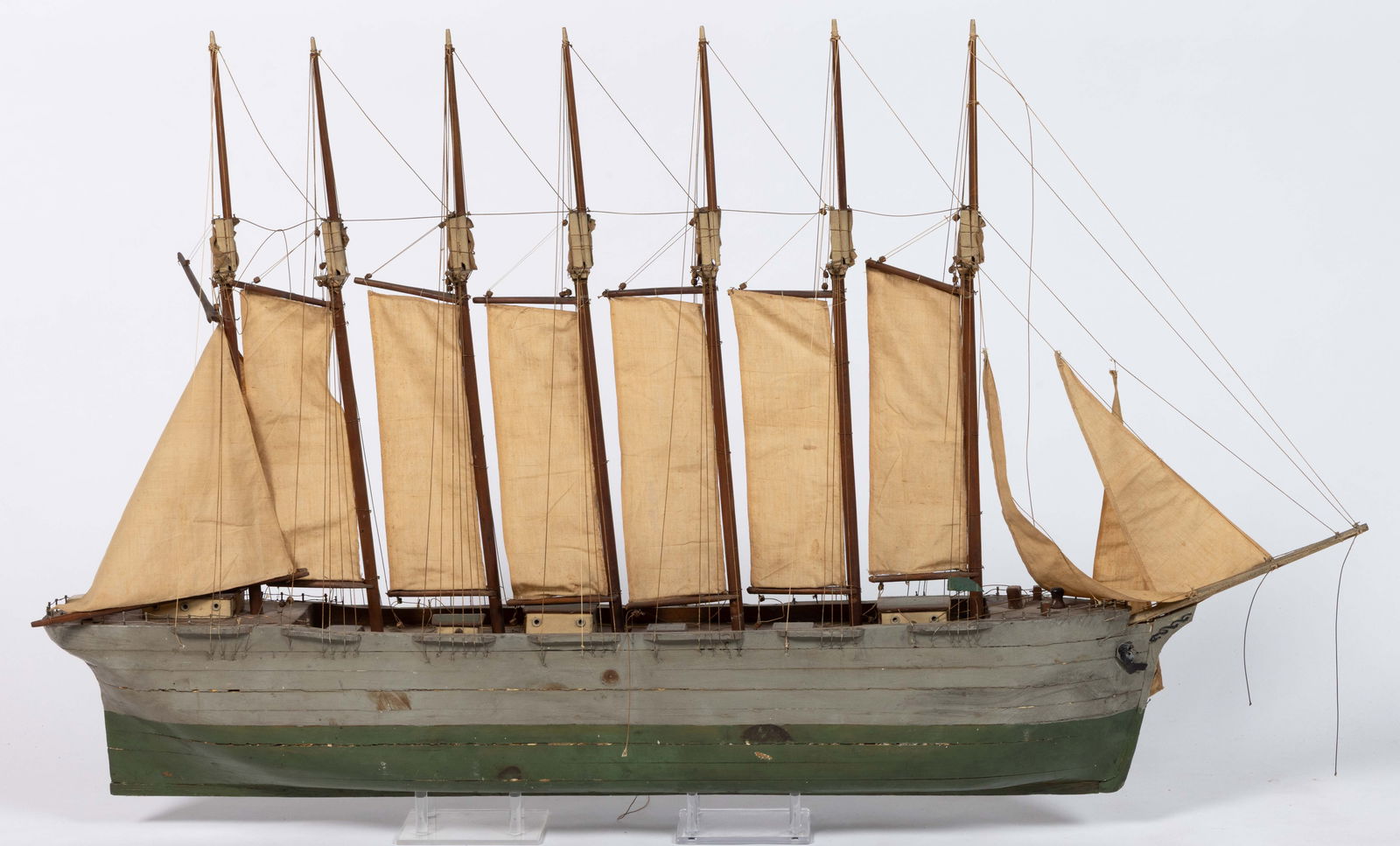 AMERICAN FOLK ART MODEL OF THE THOMAS A LAWSON SCHOONER: AMERICAN FOLK ART MODEL OF THE THOMAS A LAWSON SCHOONER, the seven-masted vessel with cream colored sails, the hull decorated in a green and grey paint-decorated scheme. First half 20th century. 24&qu