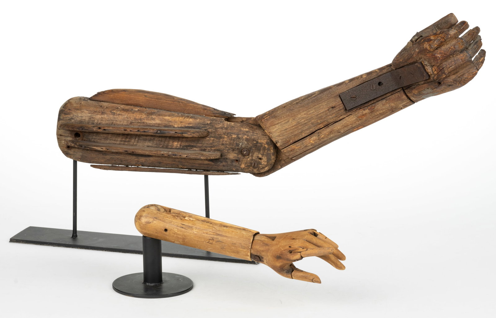 FOLK ART CARVED PINE ARTIST MODEL ARMS, LOT OF TWO: FOLK ART CARVED PINE ARTIST MODEL ARMS, LOT OF TWO, smaller example with articulated joints and several digits, each presented on an iron stand. Larger example discovered in Upstate New York. Late 19t